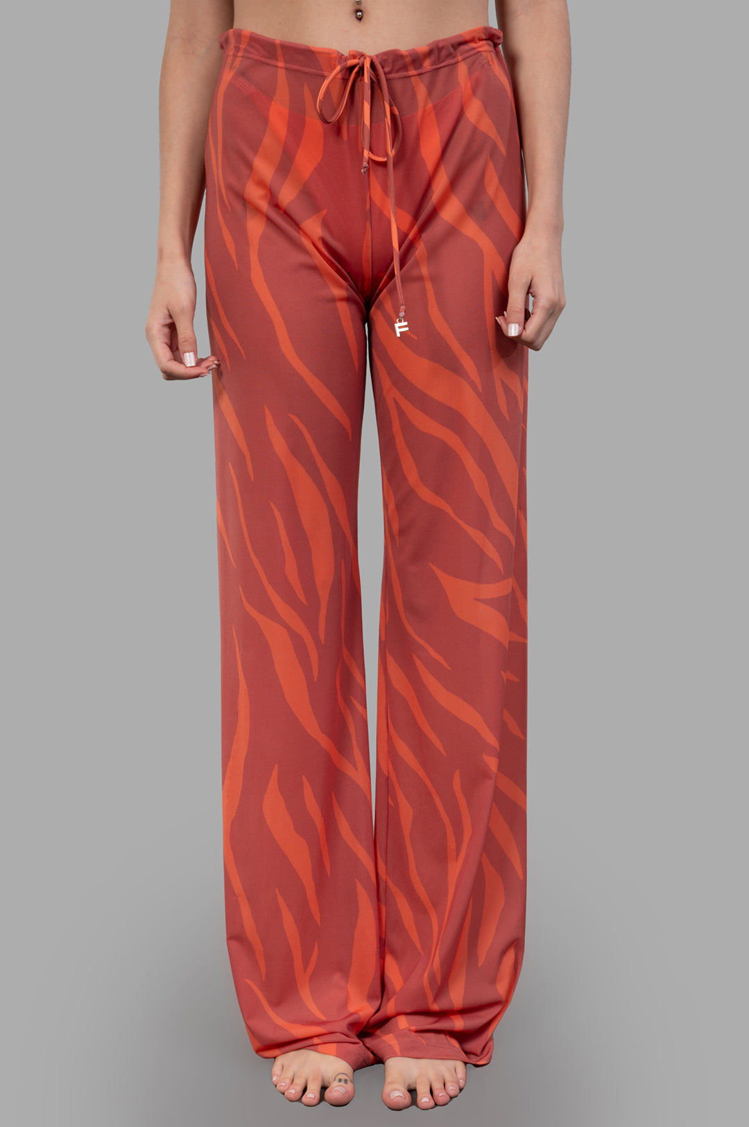 Fisico. Coral zebra-print trousers with relaxed fit, drawstring waist, and luxurious fabric showcased on model.