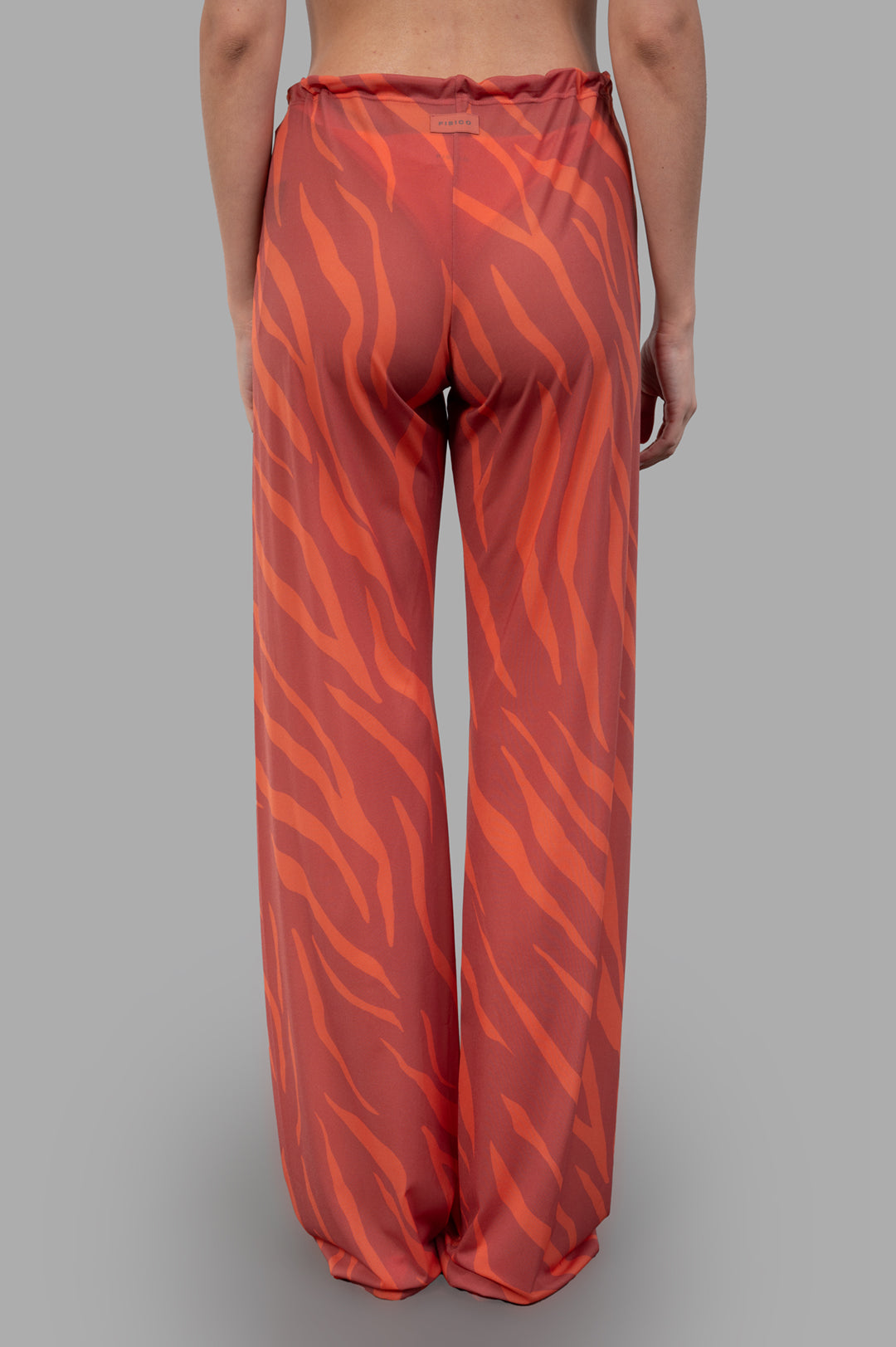 Fisico Zebra-print Trousers showcased from the back, featuring vibrant coral and orange hues with a relaxed fit.