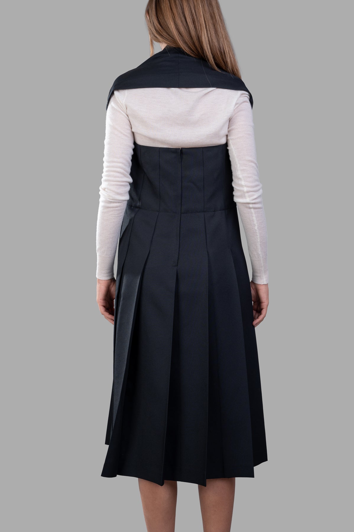 Comme des Garçons Pleated Suspender Dress, back view showcasing pleated skirt and elegant halterneck design in black.