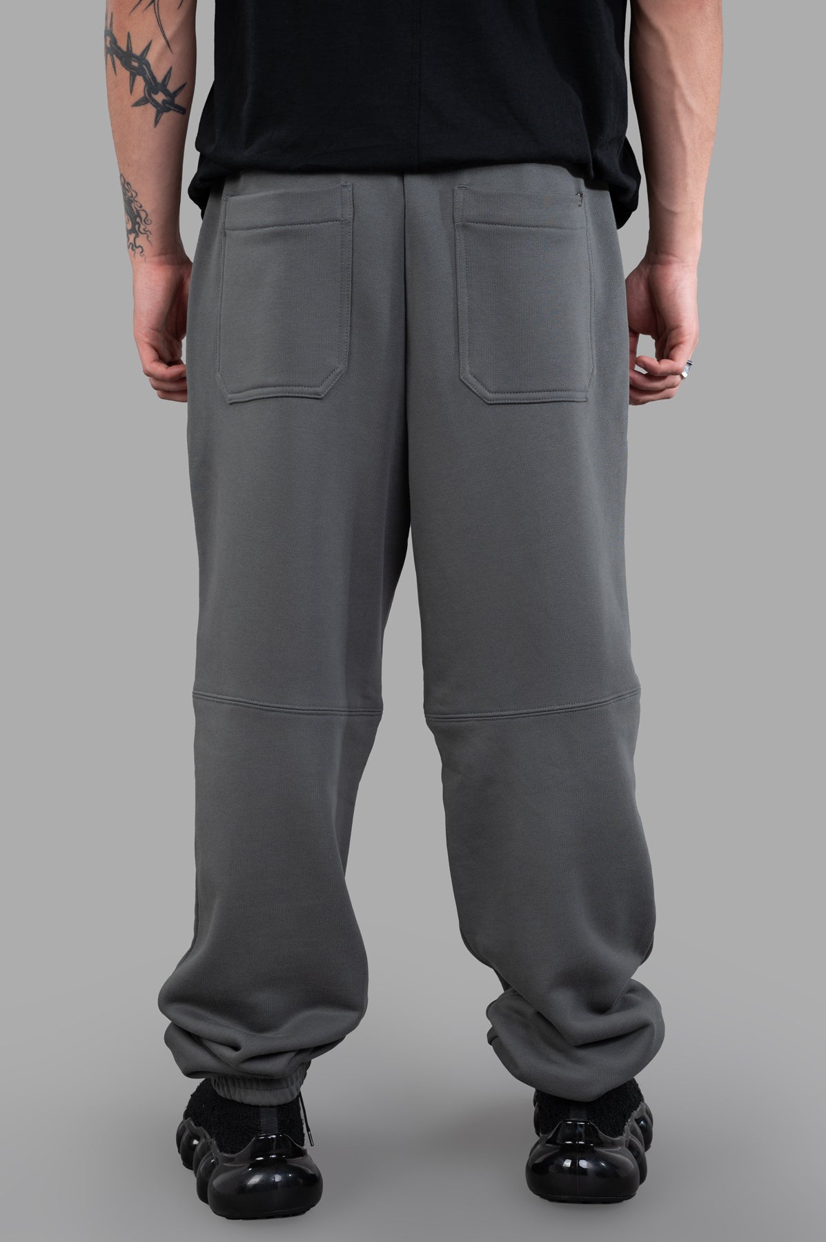 Helmut Lang Curved Sweatpants in grey, showcasing cozy cotton terry, unique seams, and signature patch pockets from the back.