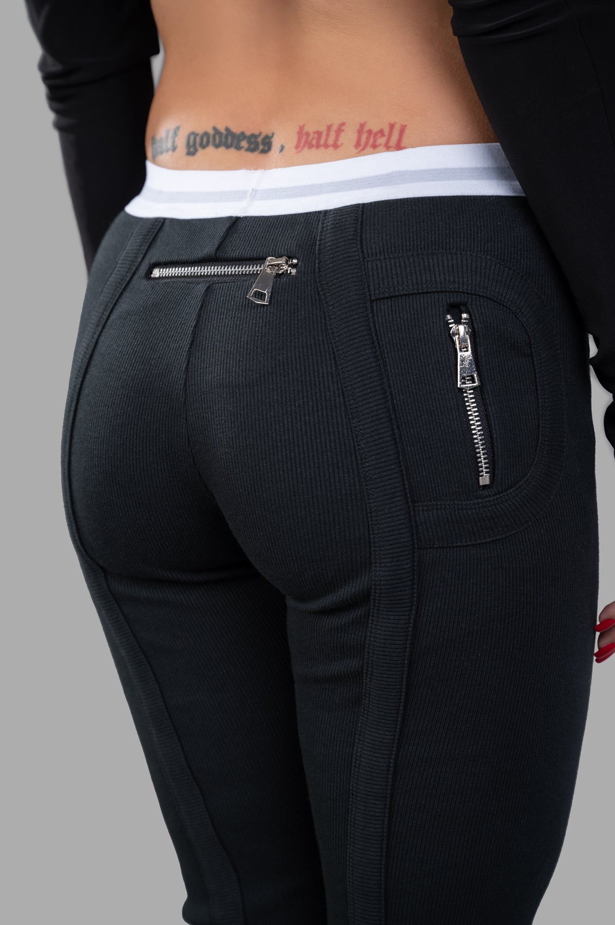 Natasha Zinko Jersey Leggings in black, featuring a stretch cotton fabric and unique zippered pocket details at the back.