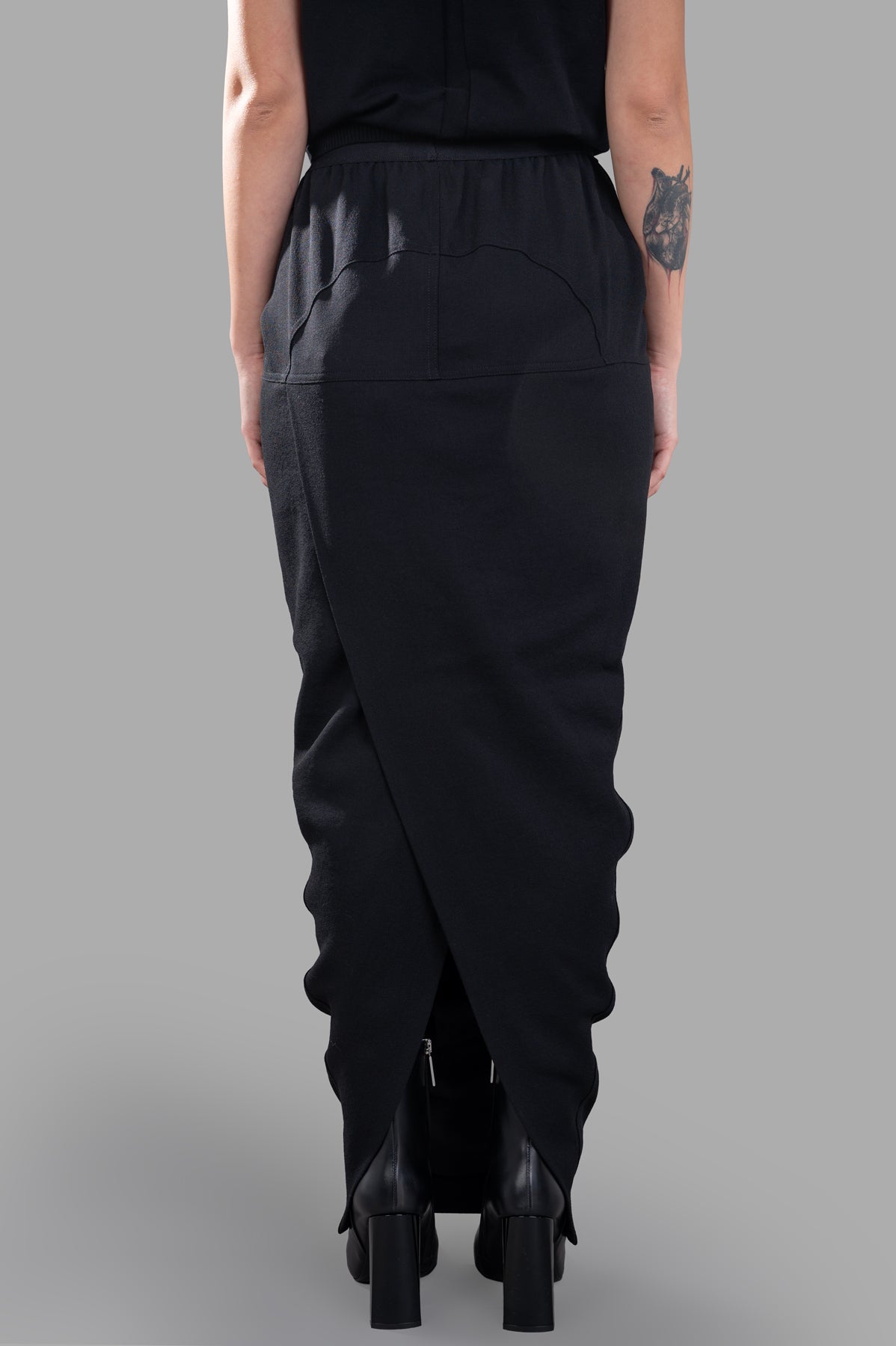 Rick Owens Long Pillar Skirt showcases an elasticized waistband with a back crossover split, elevated by tailored wool.