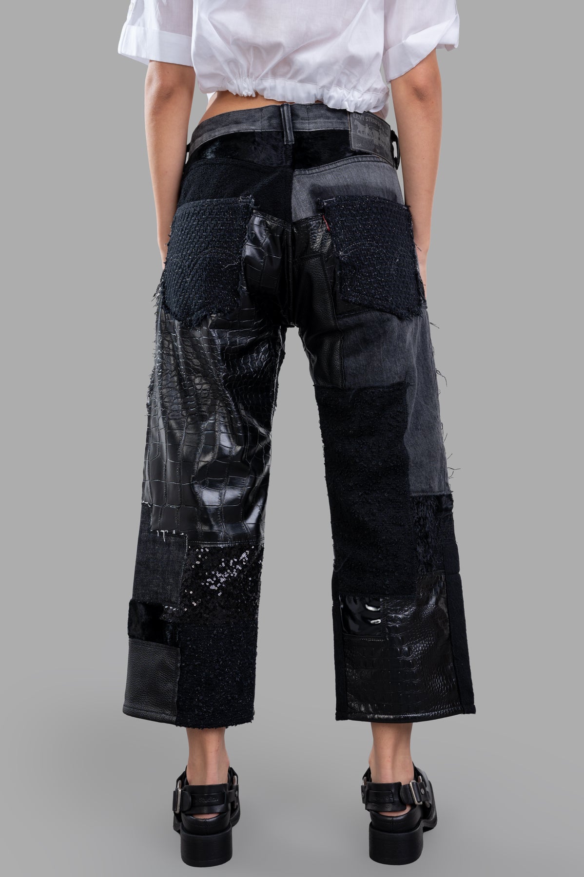 Junya Watanabe Patchwork Jeans showcasing a detailed back view, featuring a blend of denim, faux leather, and various.