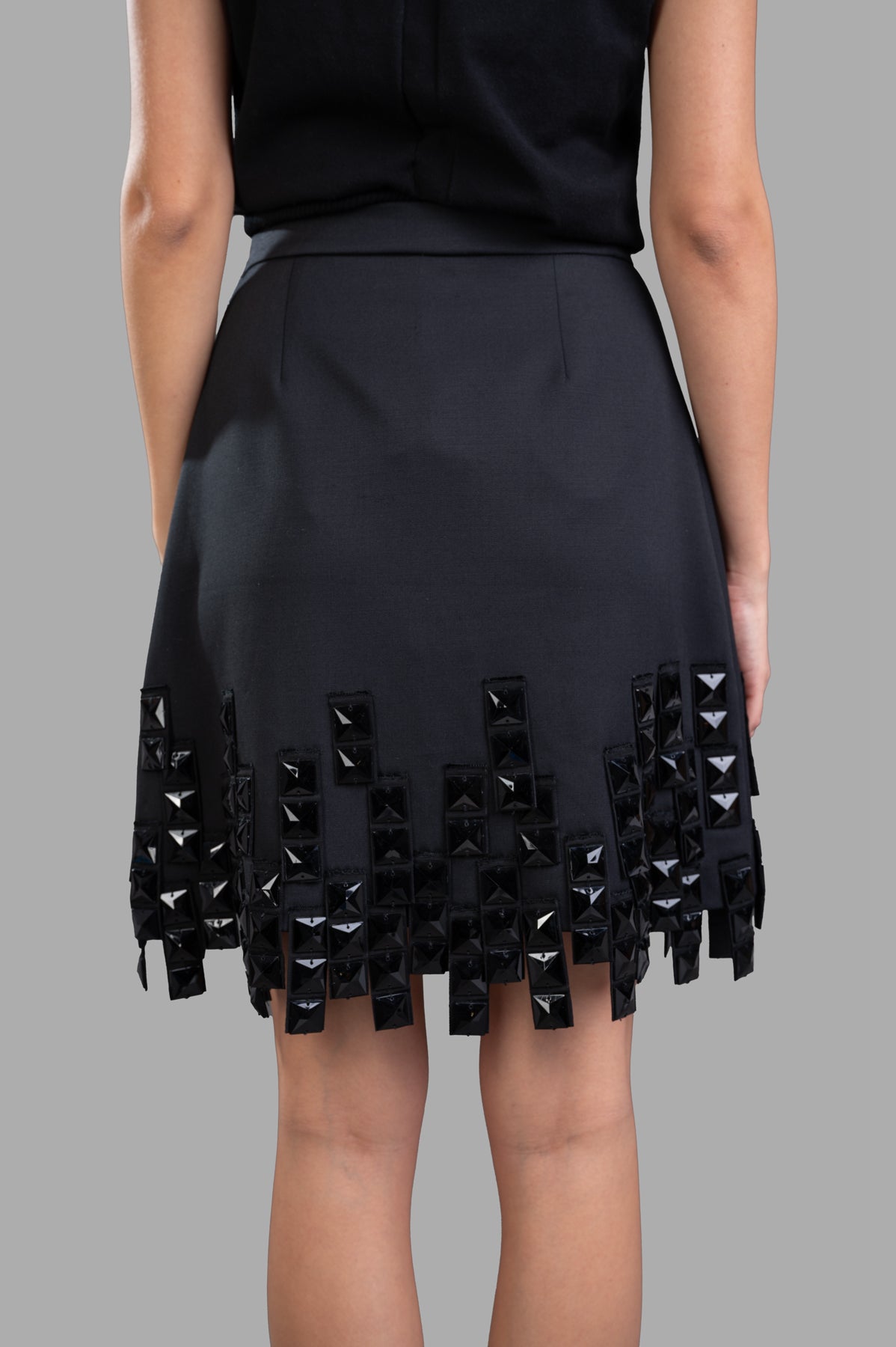 MSGM Stud-embellished Skirt, showing the intricate black bead embellishments at the asymmetrical hem from the back view.