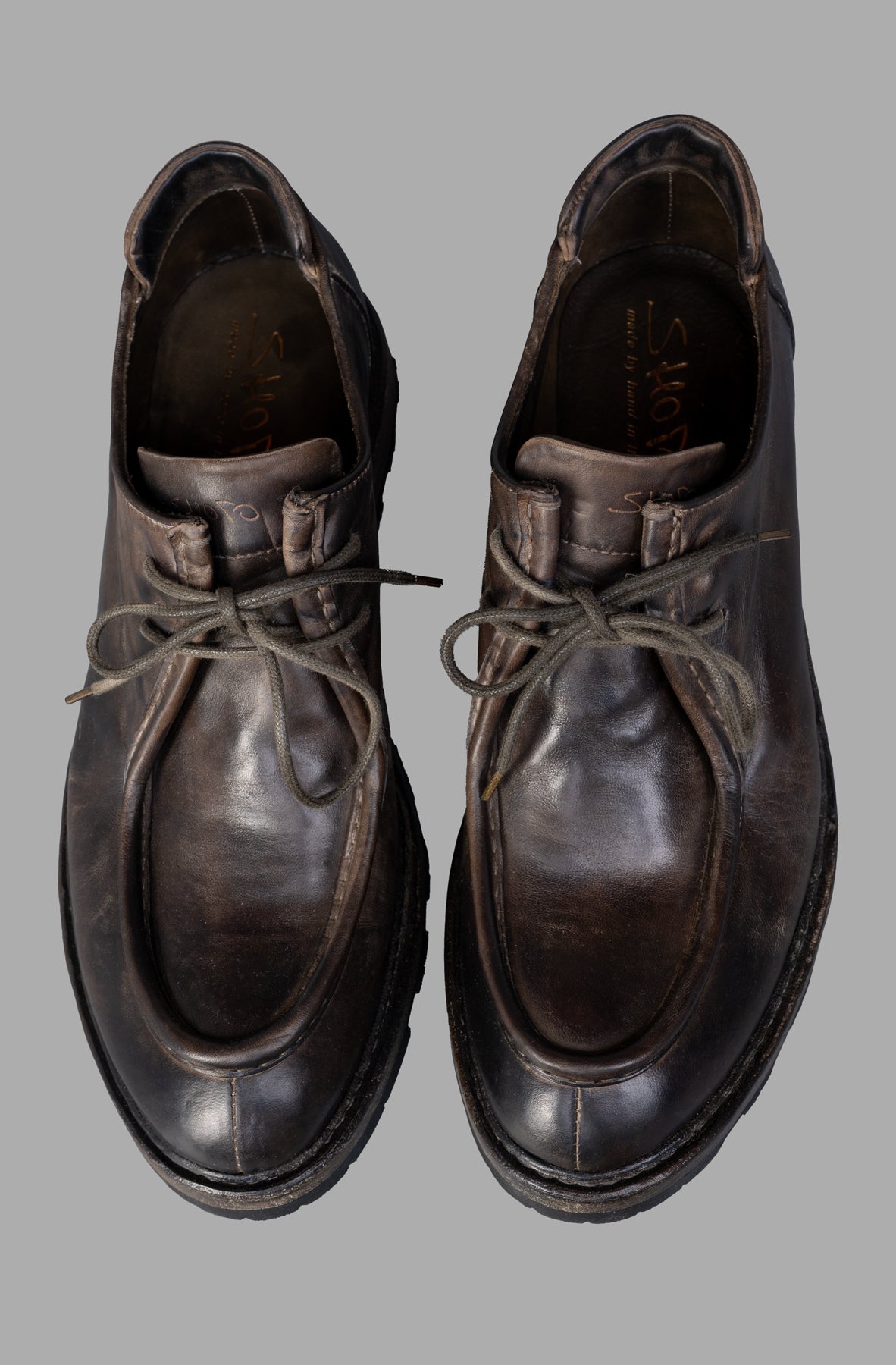 Shoto. Handmade lace-up shoes in brown leather, showcasing unique aged texture and detailed craftsmanship from above.