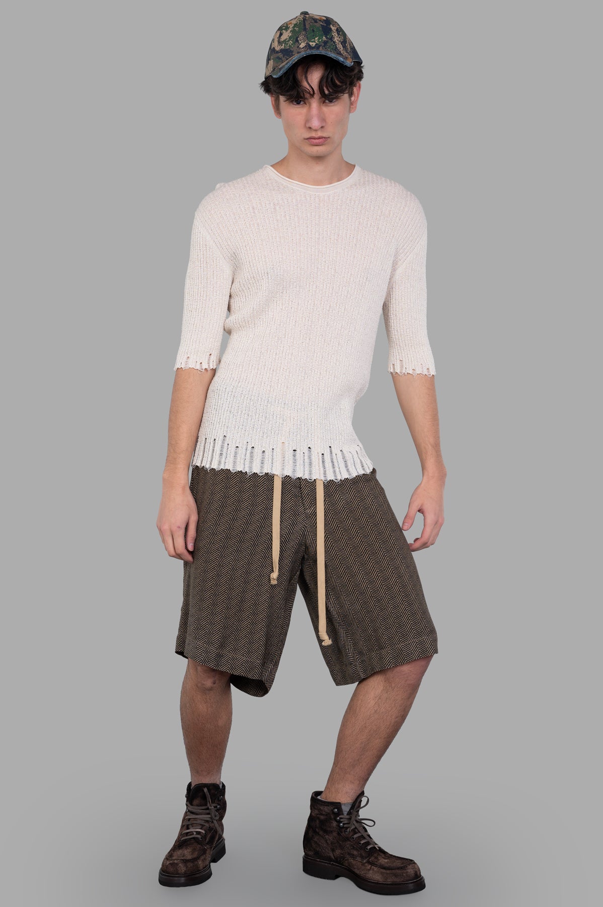 Uma Wang Herringbone Shorts in brown, front view on model, showing drawstring waist and herringbone pattern.