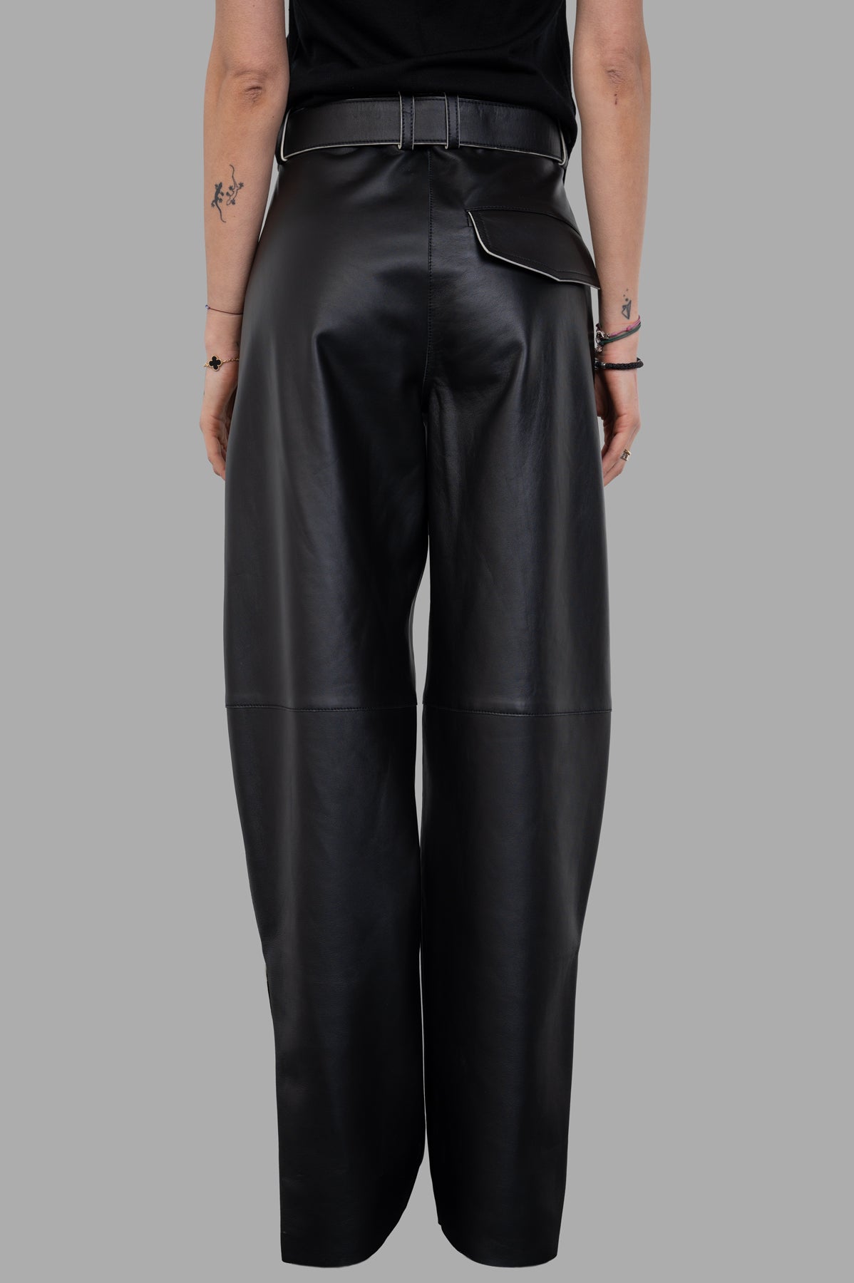 Joseph. Black Nappa Leather Trousers, wide tapered-leg view from the back, featuring a buckled belt and side pockets.