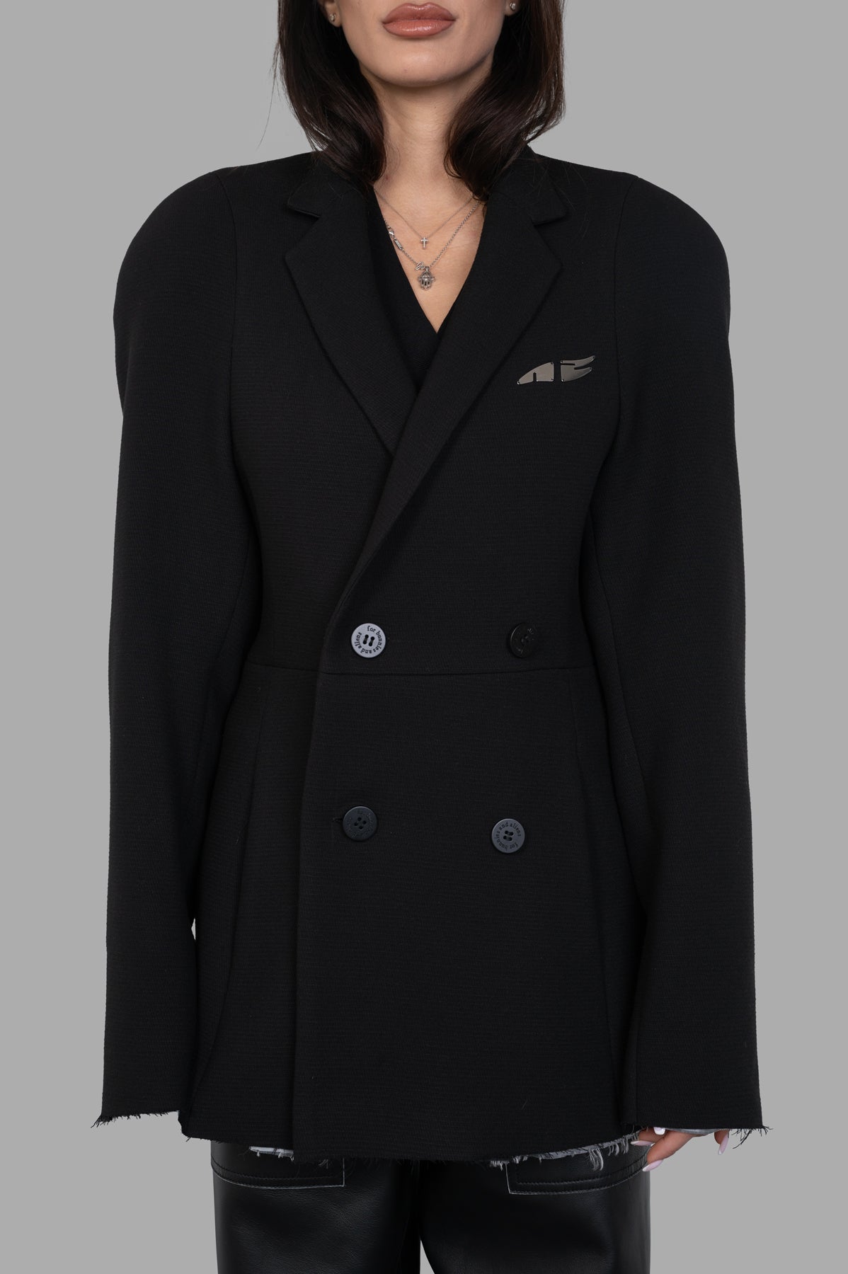 Natasha Zinko Pilot Jacket in black featuring double-breasted closure, logo detail, and oversized fit on model.