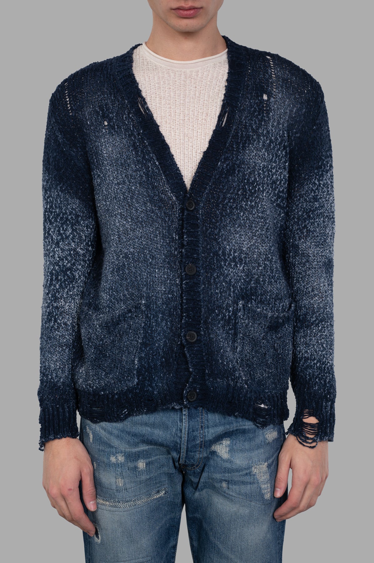 Avant Toi Distressed V-neck Cardigan in blue, showcasing distressed elements and button fastening, worn on model.