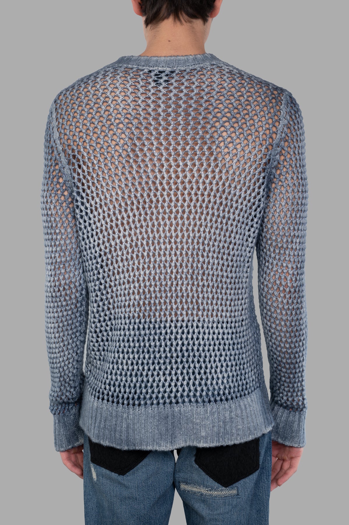 Avant Toi Blue Open-knit Sweater, showing back detail with a sheer design, paired with casual denim for a stylish look.