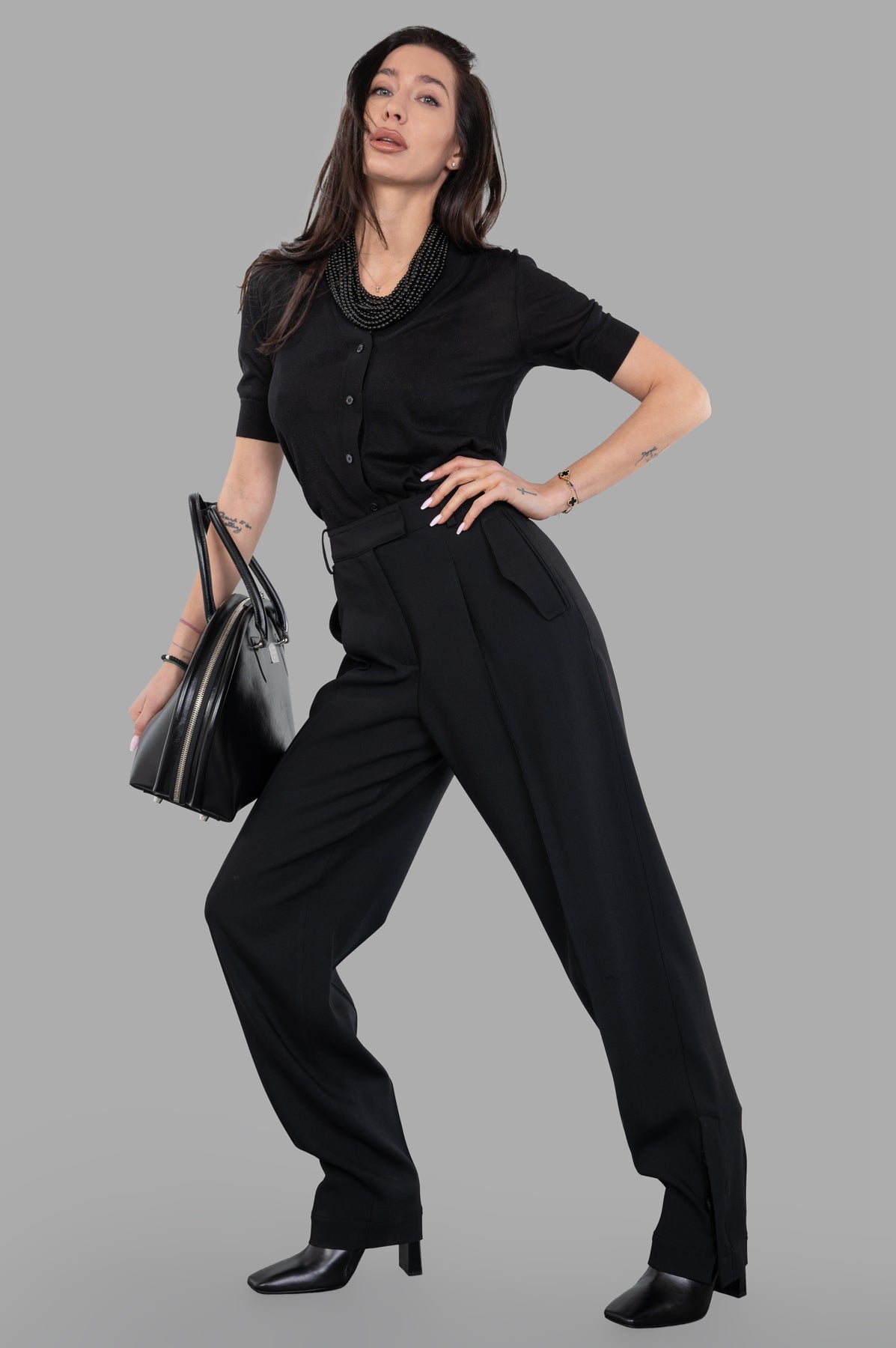 Joseph Alexis Fluid Trousers on model, front view, paired with black top, heels, and handbag.