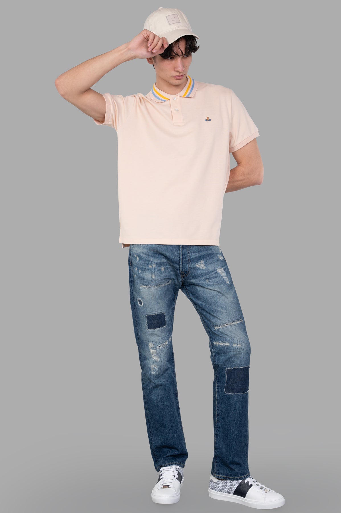 Vivienne Westwood Classic Polo Shirt in plaster pink, on-model front view, featuring striped collar and iconic orb motif.