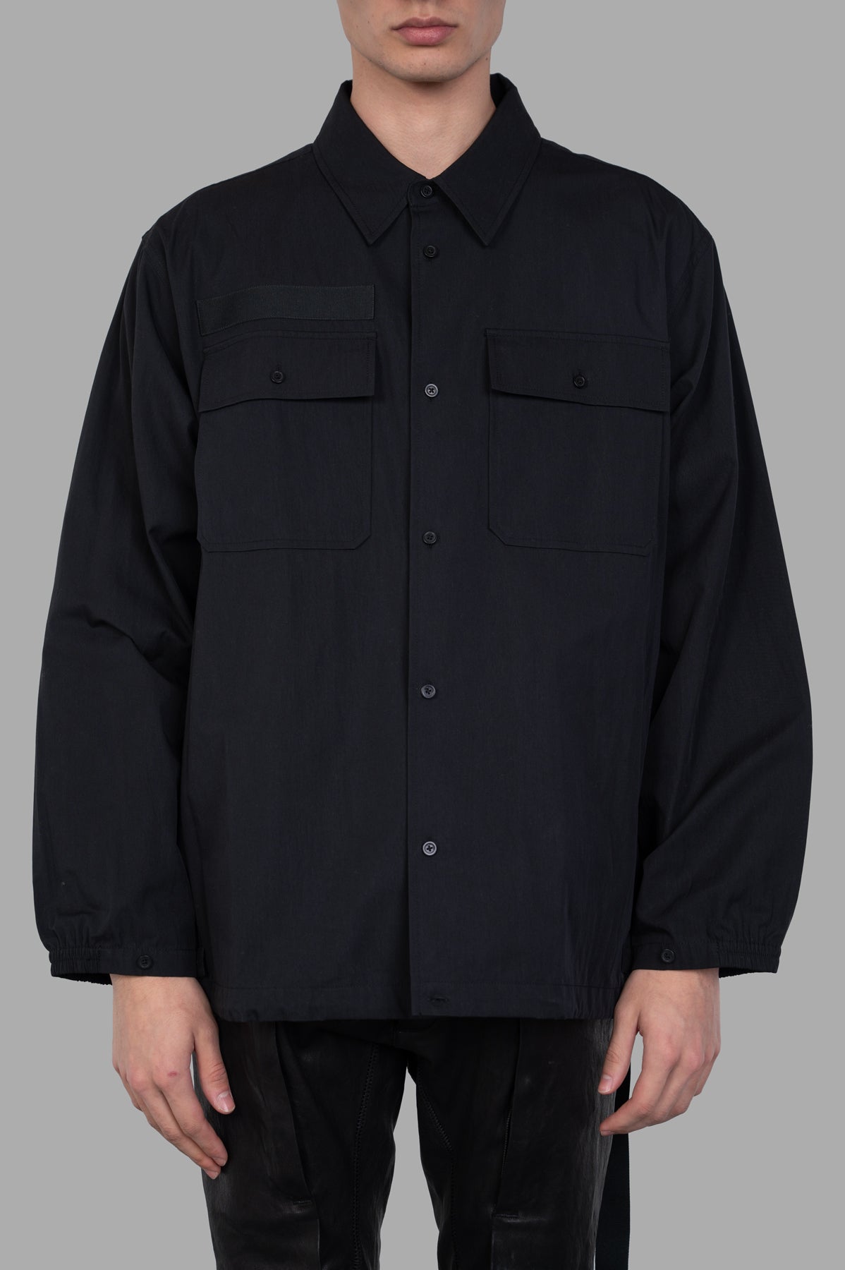 Helmut Lang Uniform Shirt displayed on a model, featuring a black button-down design with military-inspired pockets.