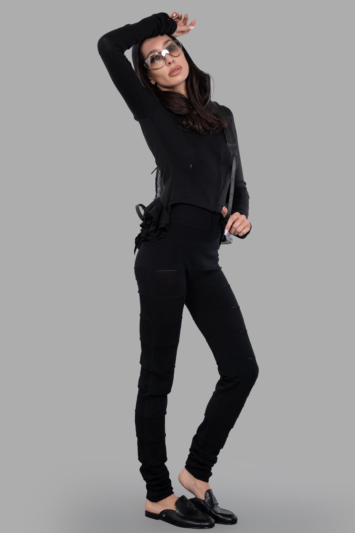 Natasha Zinko Ruffled Hooded Jacket in black on model, showcasing side view with fitted design and ruffled back detail.