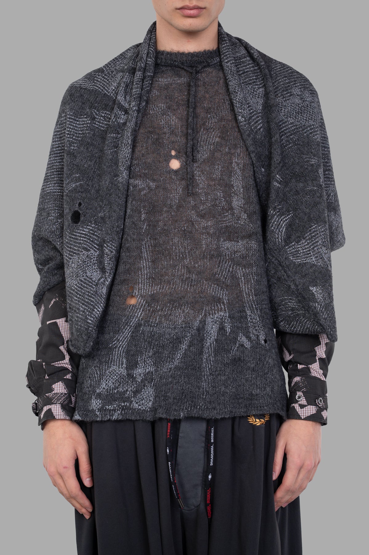 Vivienne Westwood Hi-Vis Poncho Scarf displayed on a model, showcasing its grey alpaca-blend fabric and unique motif design.