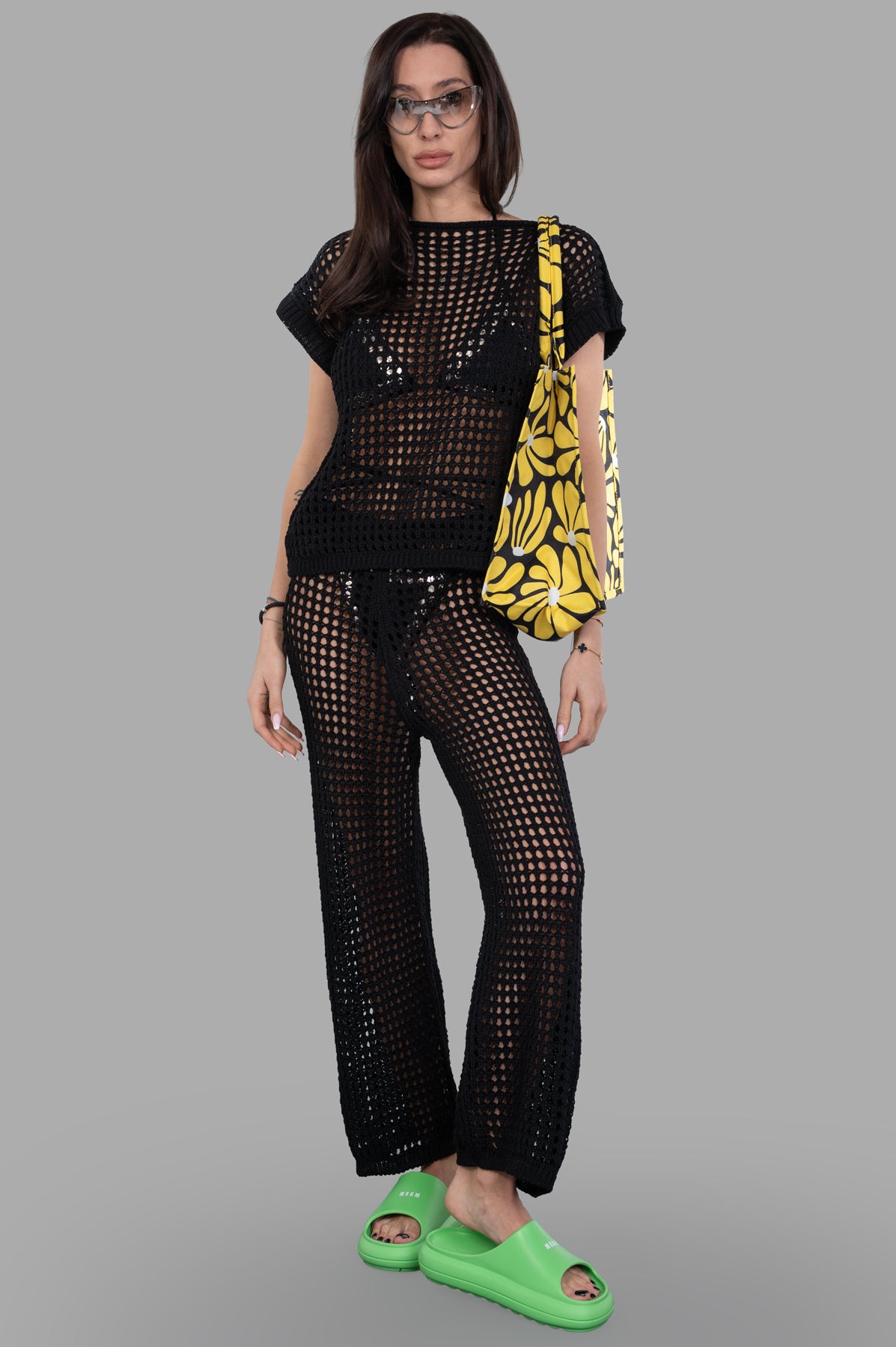 Marc Point Beach Cover-Up Pants in black crochet, front view, on-model with yellow tote and green slides.