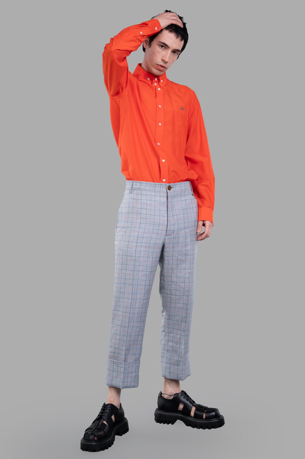 Vivienne Westwood Cropped George Trousers styled on-model, showcasing blue Prince of Wales check with turn-up cuffs.