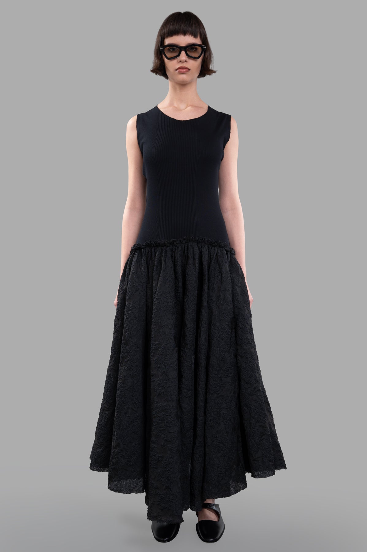 Marc Point Long Bustier Dress in black, showcasing a sleeveless top and a flowing, textured maxi skirt on model.