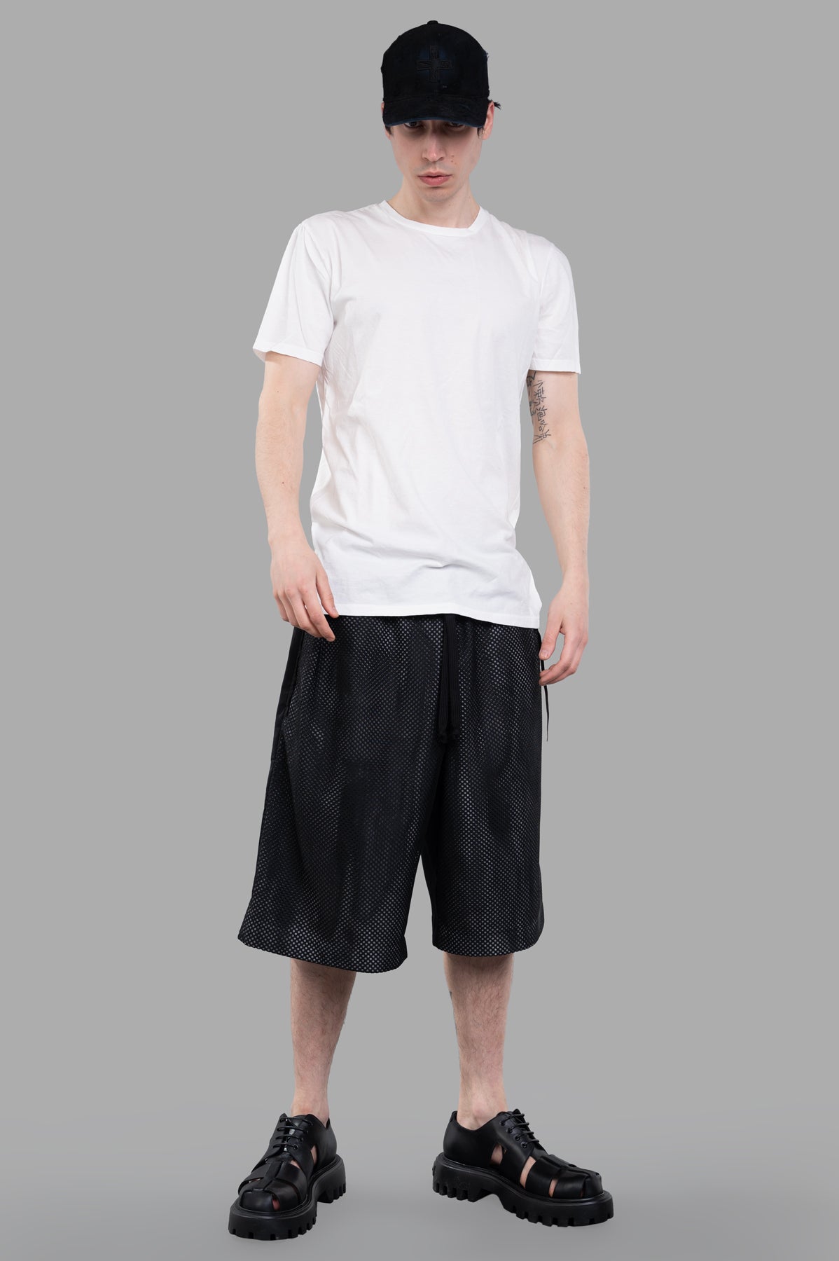 Giovanni Cavagna Perforated Shorts in black, front view on model, showcasing breathable mesh fabric with relaxed fit.