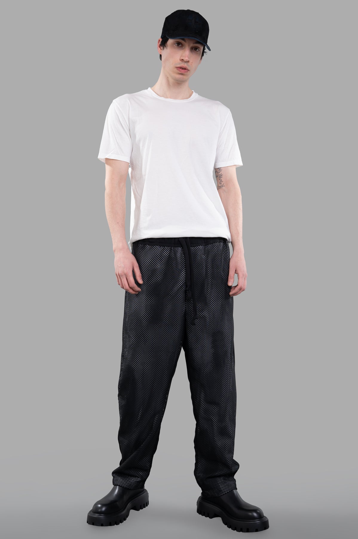 Giovanni Cavagna black perforated pants modeled from the front, highlighting relaxed fit and breathable fabric.