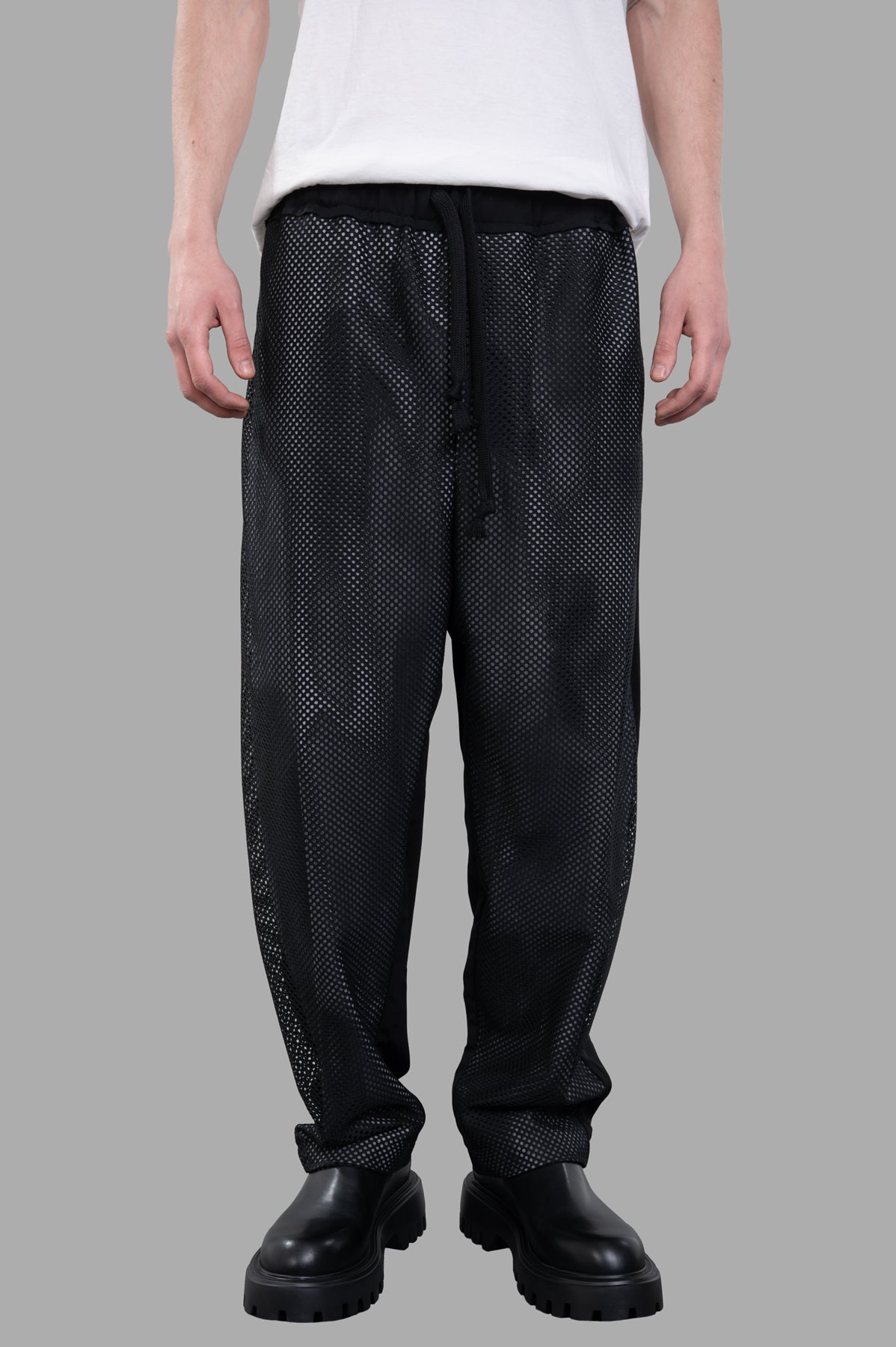 Giovanni Cavagna Perforated Pants in breathable black fabric, featuring a relaxed fit and elastic drawstring waistband.