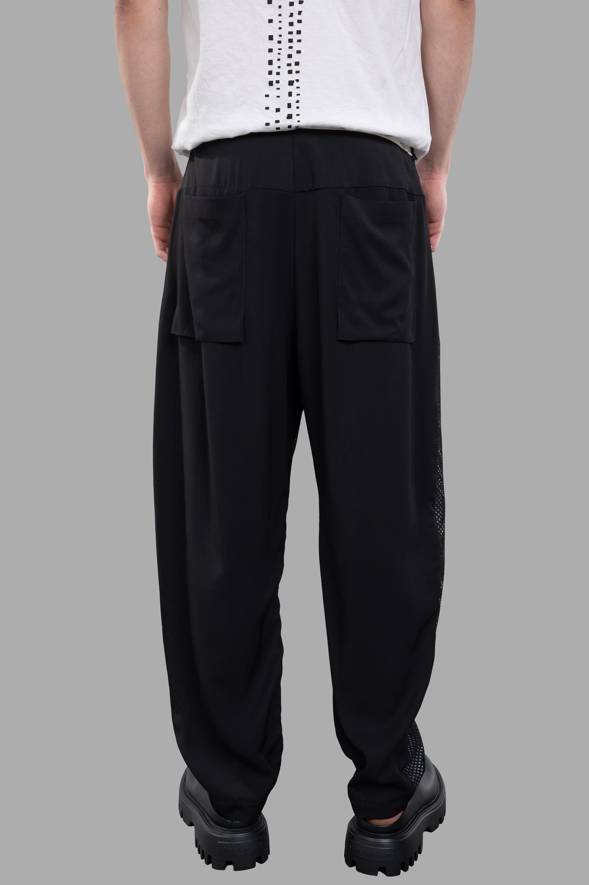 Giovanni Cavagna Perforated Pants in black, relaxed fit, showcasing breathable fabric and back pocket details on model.