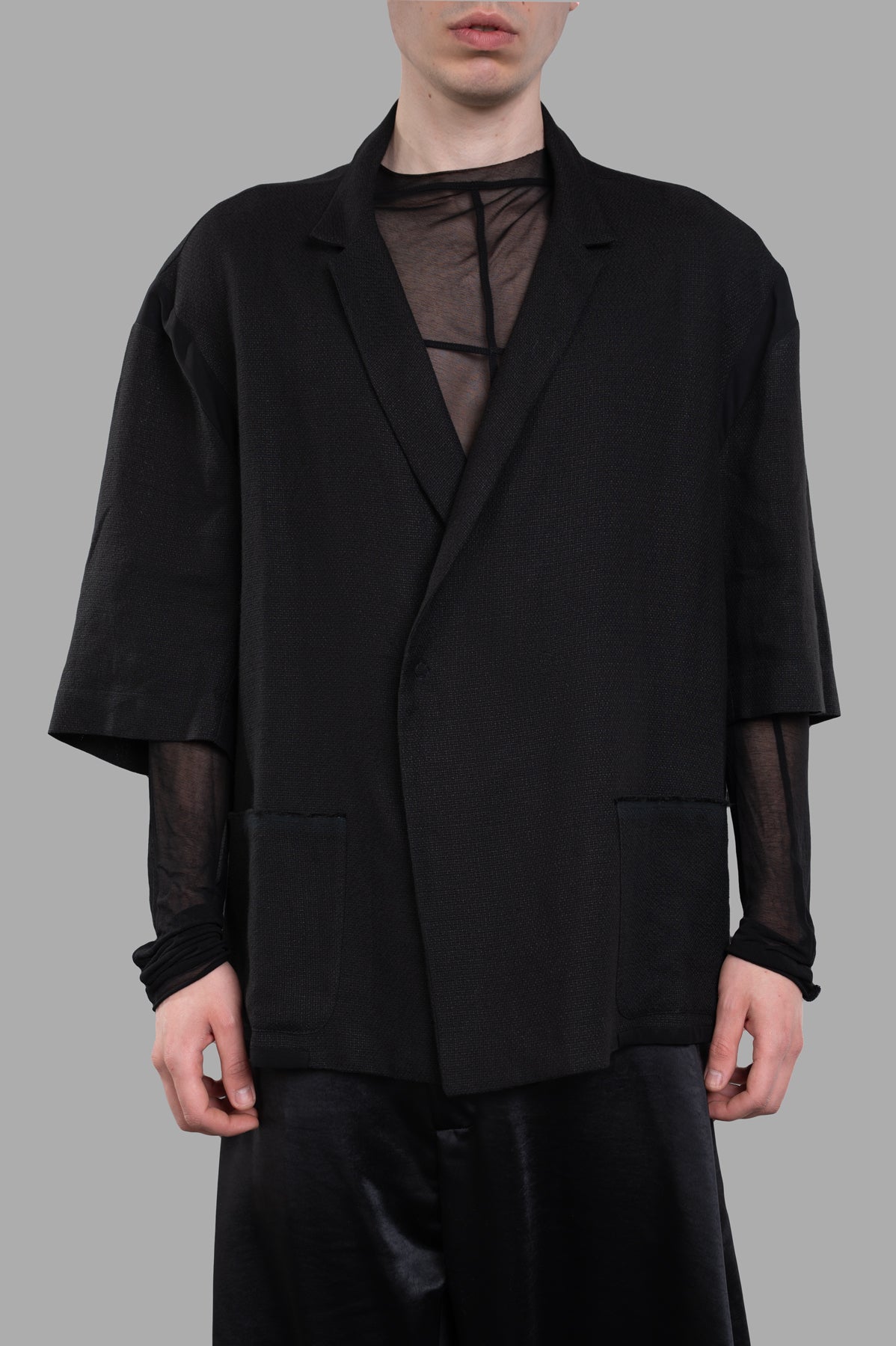 Giovanni Cavagna Cropped-sleeve Blazer, black, showcasing 3/4 sleeves and asymmetric fastening, worn on model.