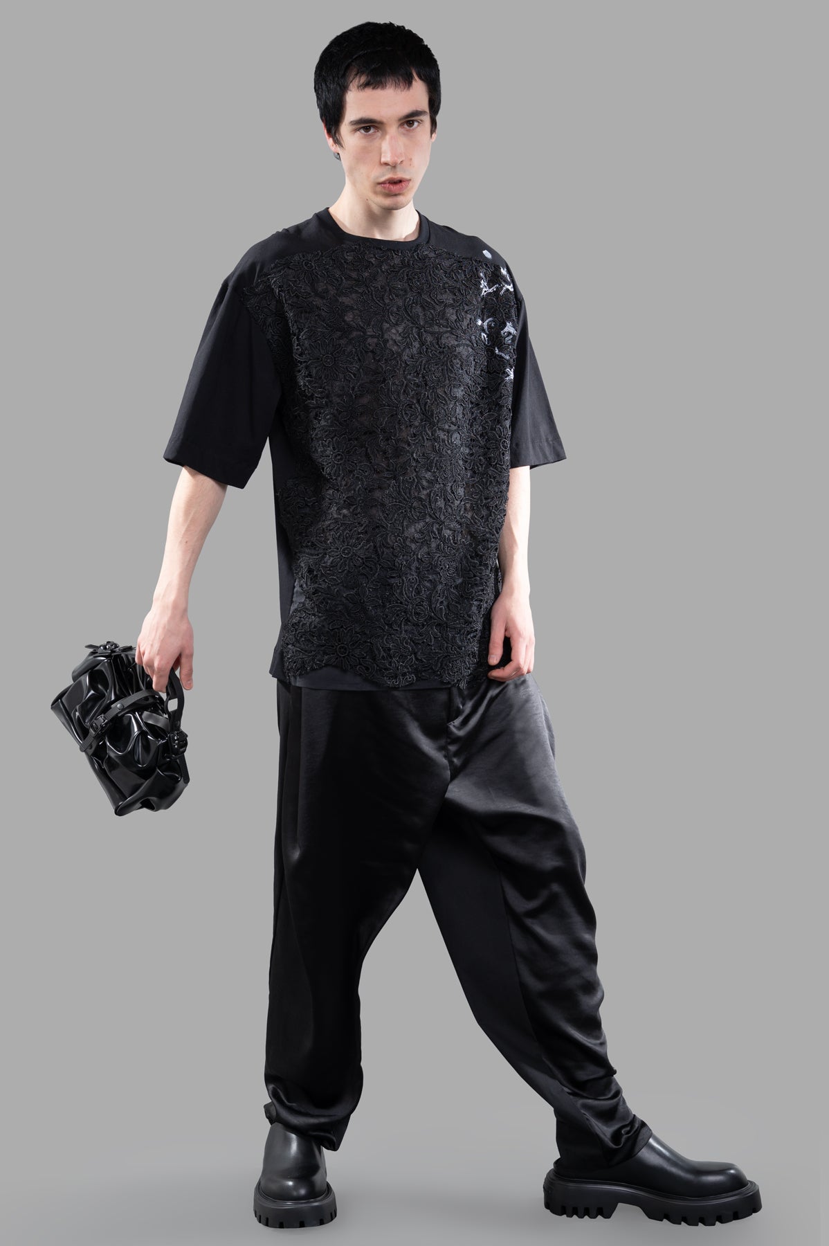Giovanni Cavagna black lace-detail T-shirt, front view on model, oversized fit, intricate lace texture, bold style.
