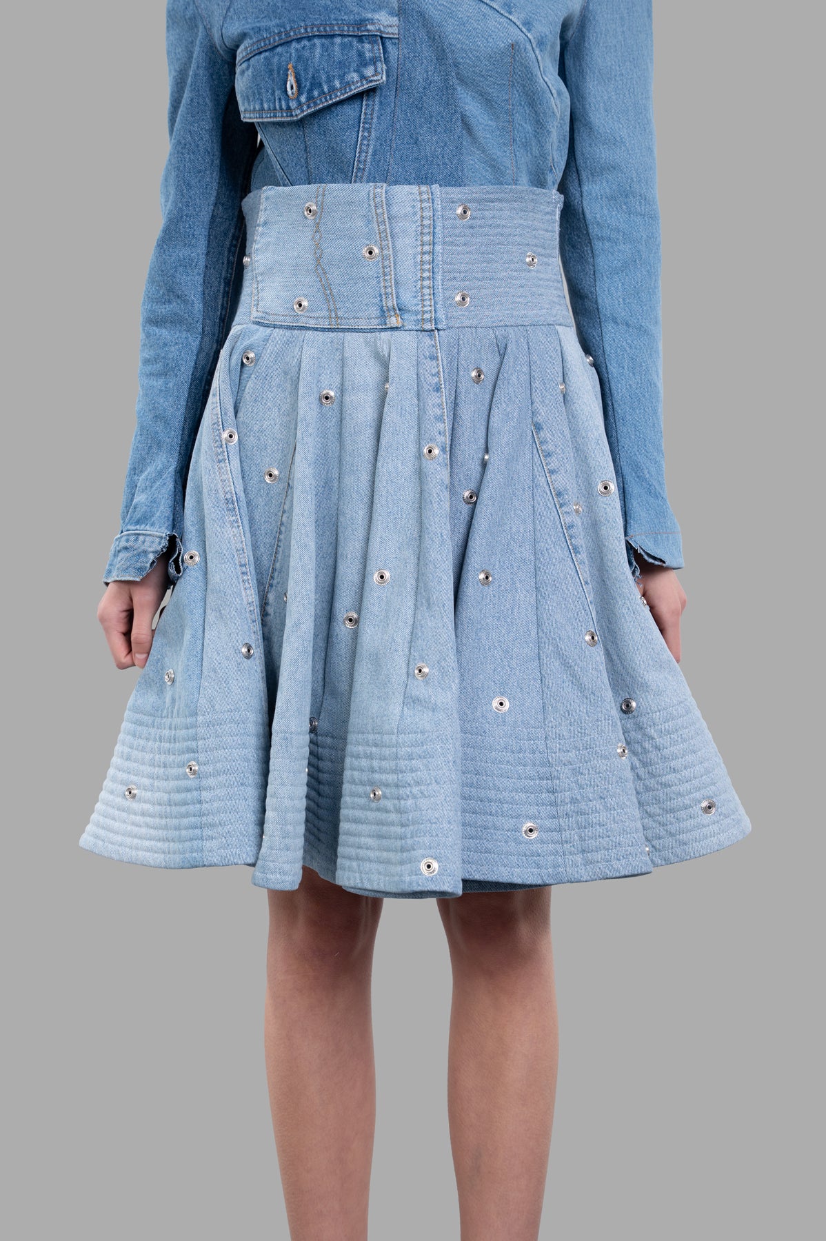 A.W.A.K.E. MODE Recycled Denim Skirt, high-waisted blue midi skirt with snap buttons, showcased from the front on a model.