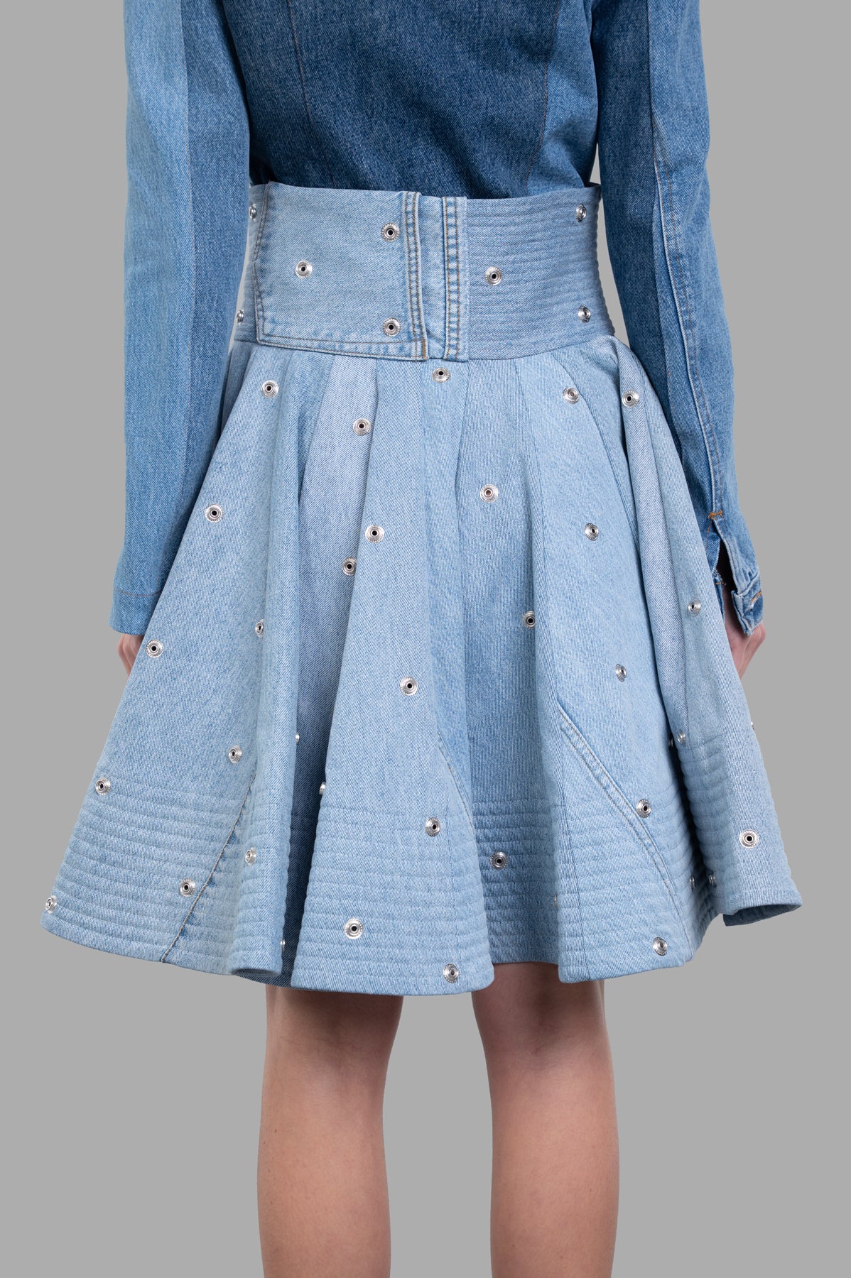 A.W.A.K.E. MODE Recycled Denim Skirt featuring a high-waisted design, detailed snaps, and a full silhouette in blue.