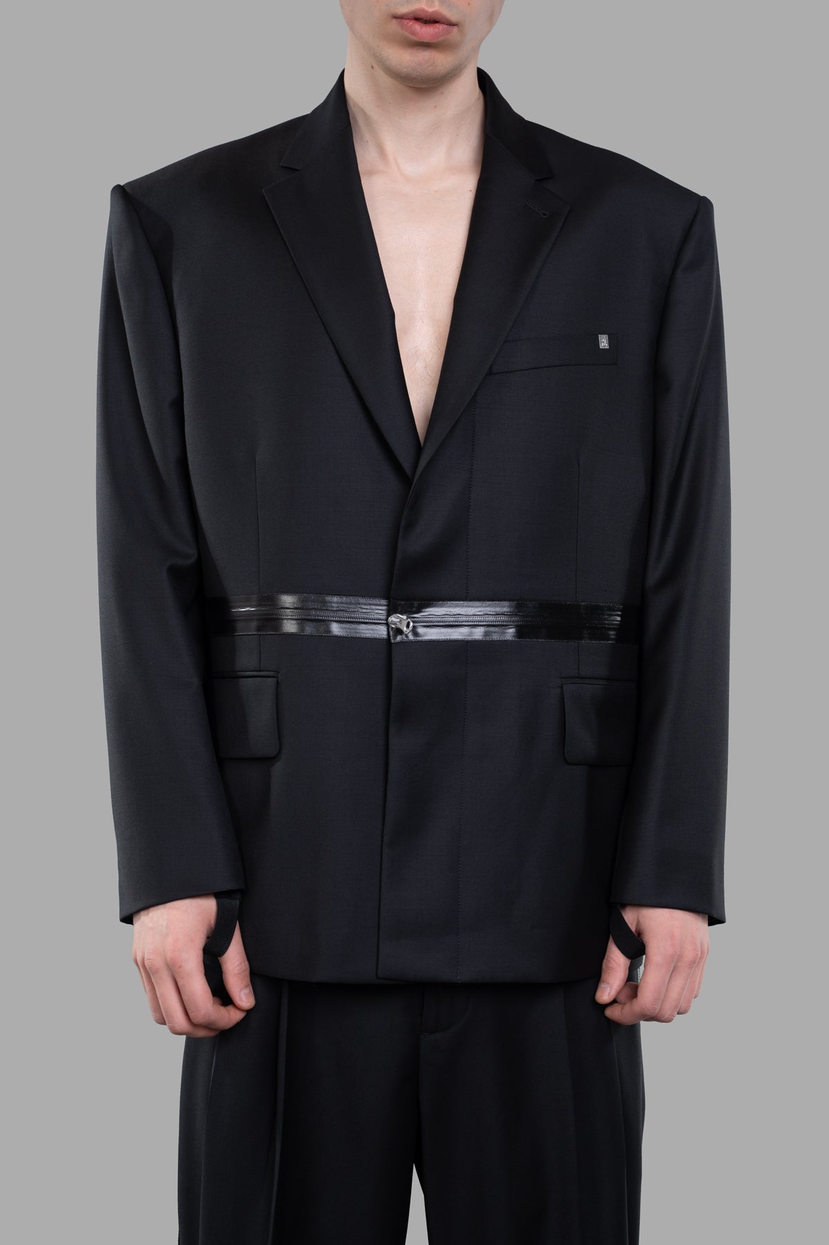 Helmut Lang Zip Driver Blazer in black wool twill, featuring oversized fit, notched lapels, and tonal zip detail, on model.