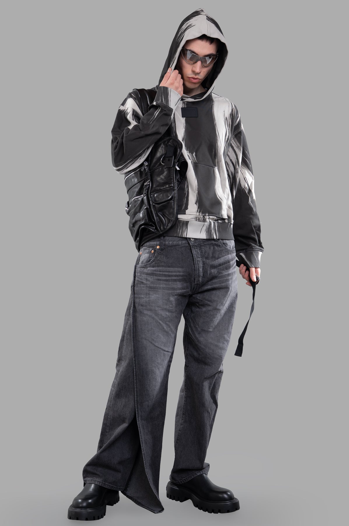 Helmut Lang Feather Studio Hoodie in grey, all-over print, front view on model with sunglasses and black bag.