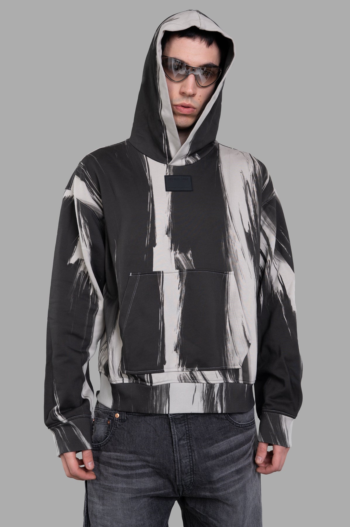 Helmut Lang Feather Studio Hoodie in grey, featuring exclusive all-over print, shown on model from the front.