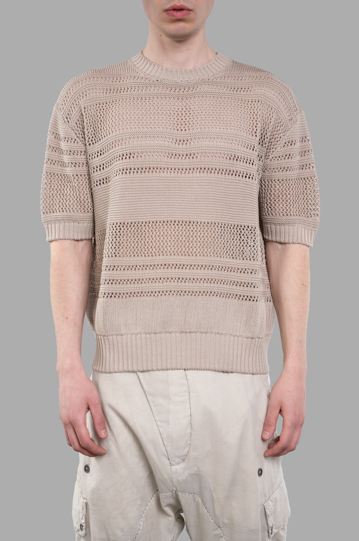 AION Perforated-mesh T-shirt in beige, showcasing ribbed texture and short sleeves on a model, highlighting breathability.