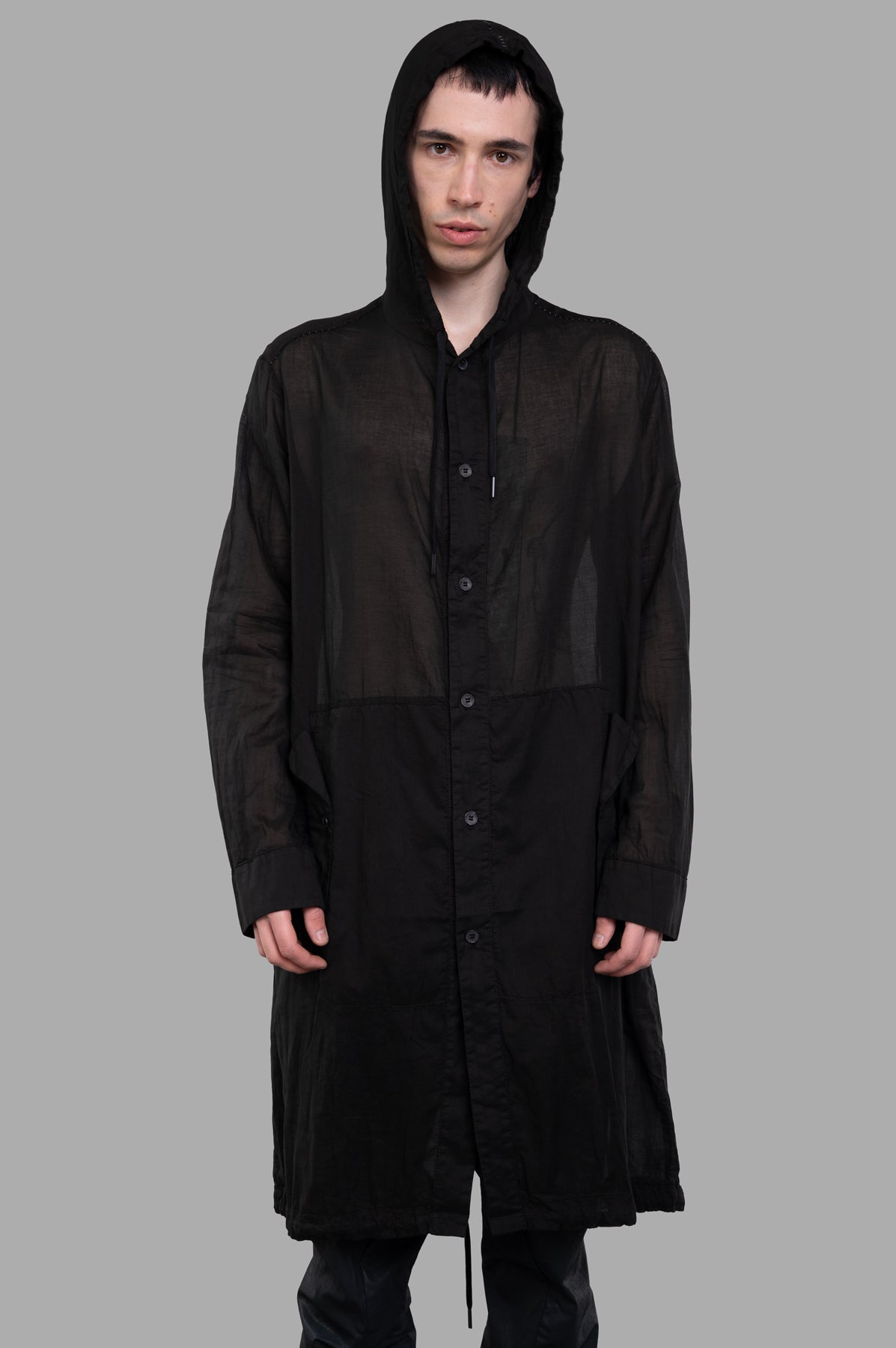 Masnada Sheer Parka in black, featuring a lightweight, transparent design with a hooded style, shown on a model.