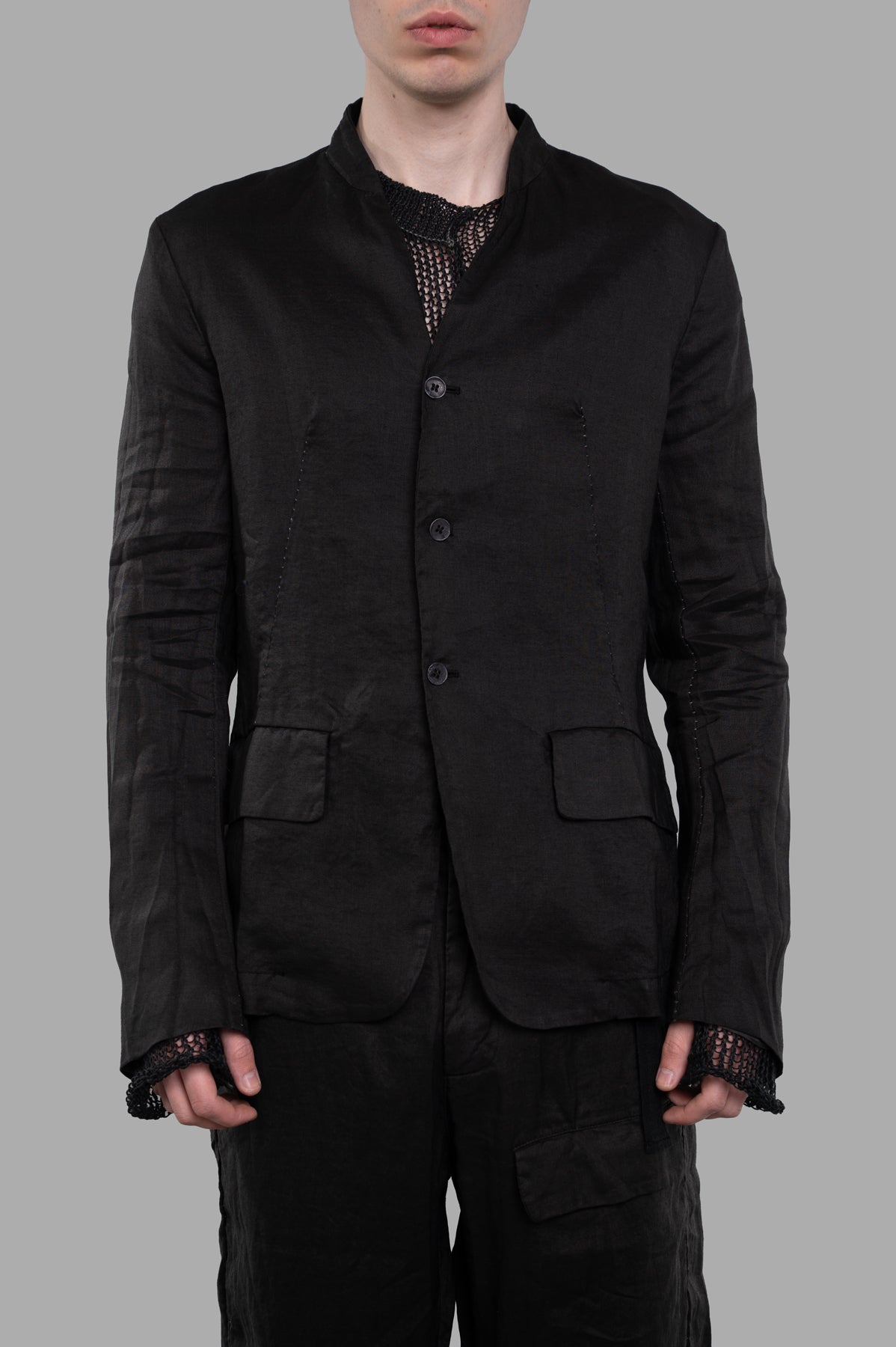 Masnada Single-breasted Blazer shown from the front, featuring a collarless design and side flap pockets in black ramie.