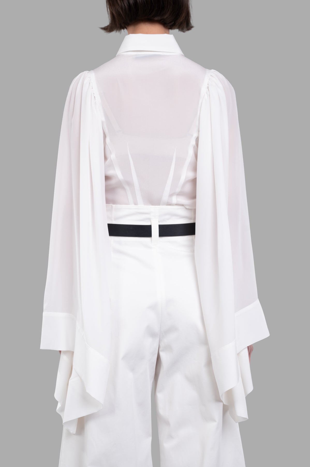 Sehnsucht Atelier Bell-sleeve Shirt displayed on a model from the back, featuring flowing sleeves and elegant design details.