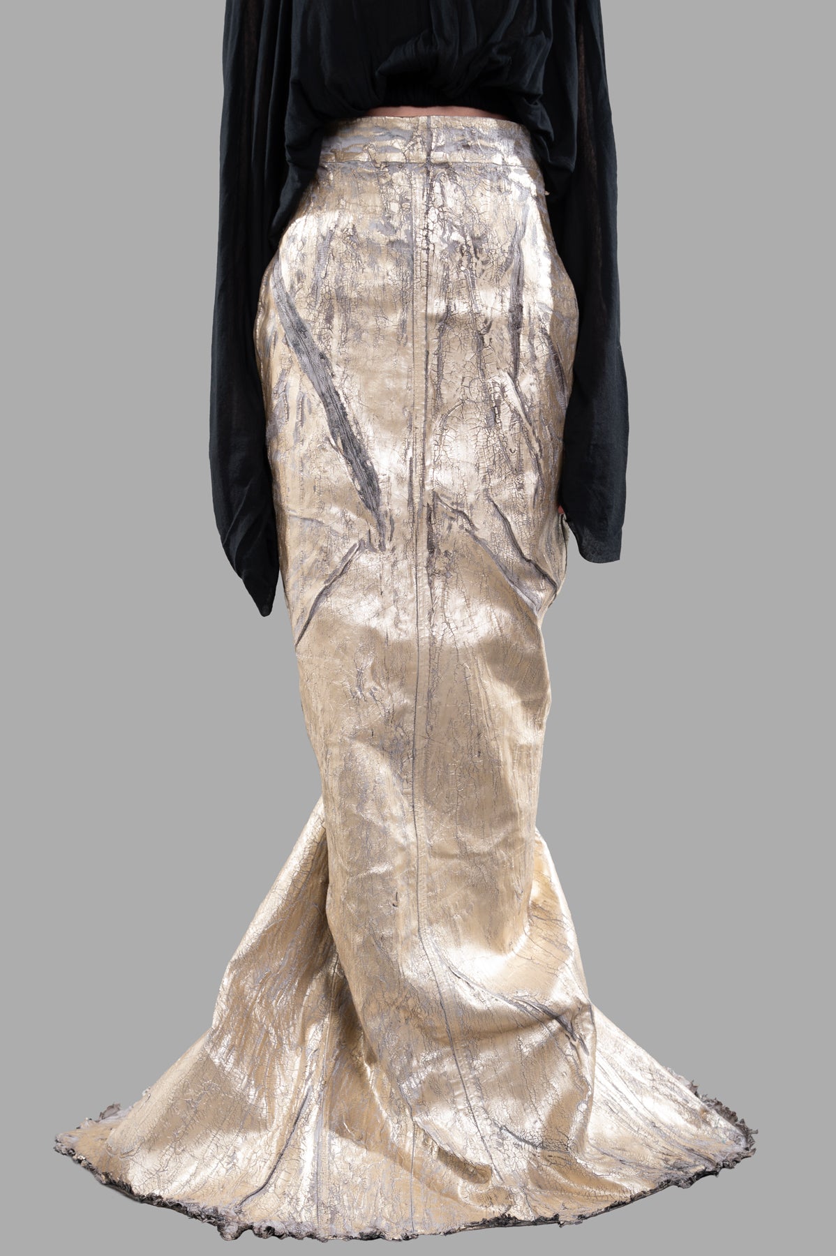 Rick Owens Lido Maxi Skirt in gold, showcasing luxurious sheen and flowy train, worn with a black top for a bold look.