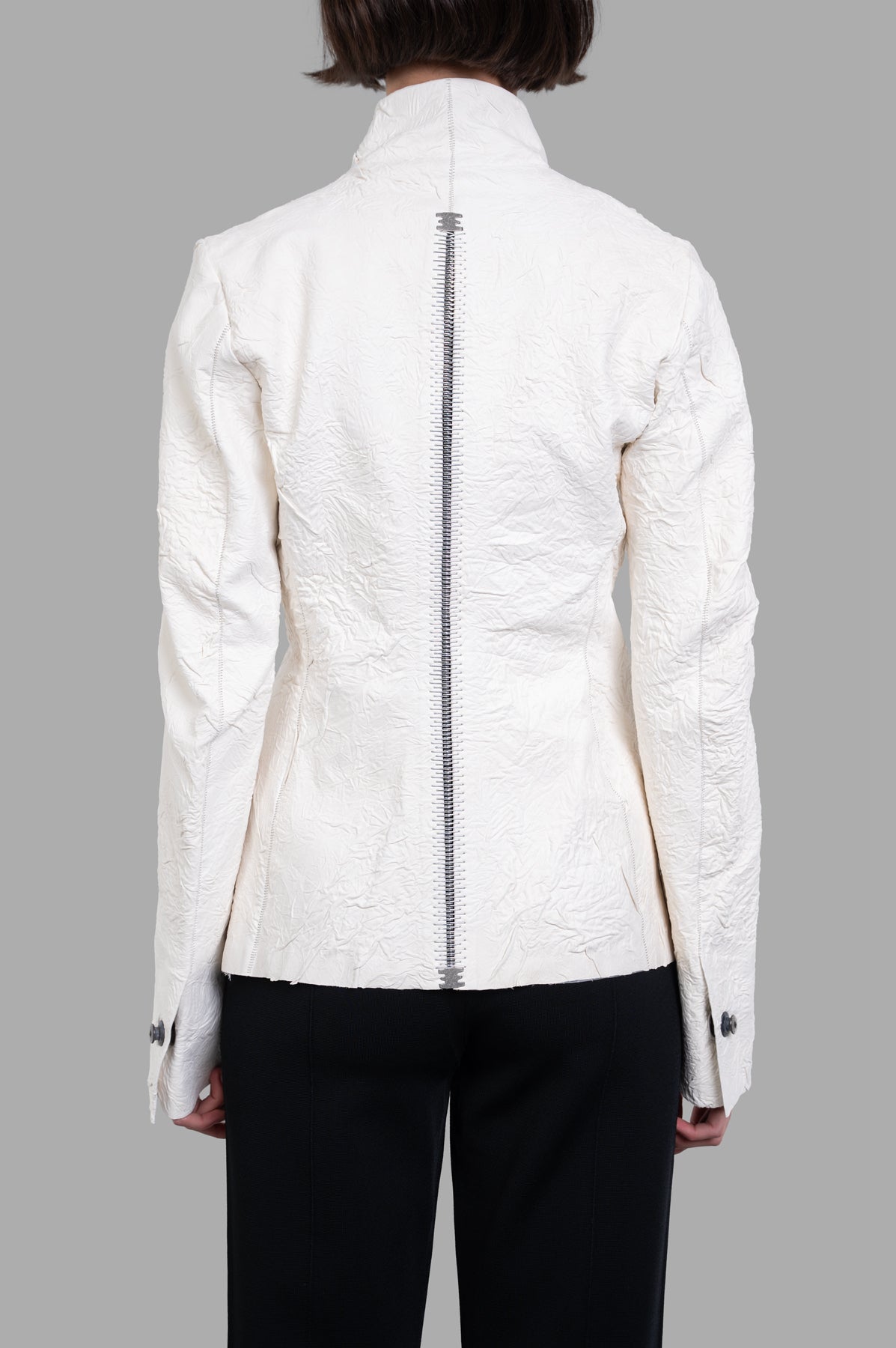 Isaac Sellam Fitted Leather Jacket in ecru, showcasing a textured back with scalloped seams and a zipper detail.