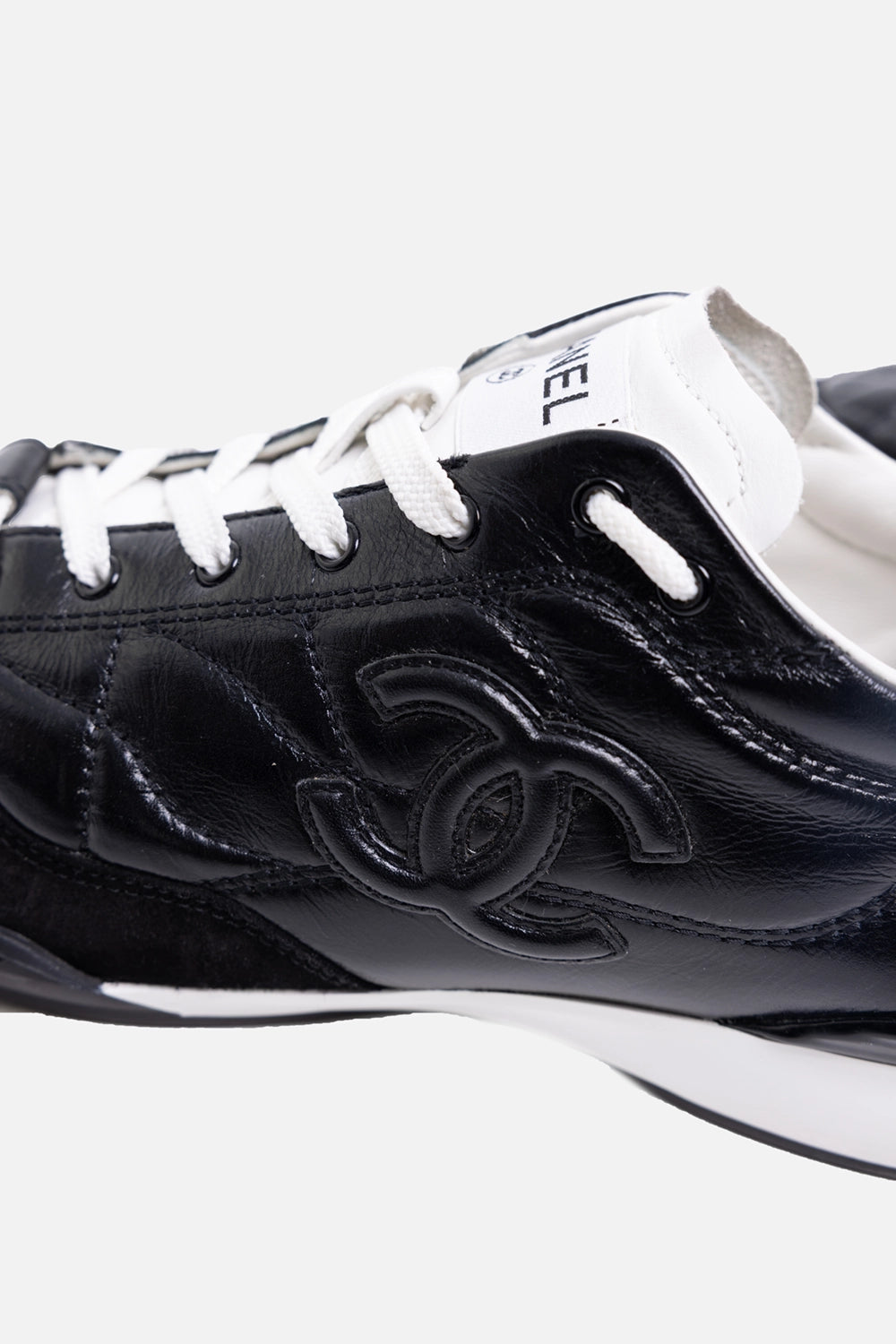 Pre-owned Chanel women’s low-top sneakers in black and white, logo detail view, quilted leather panel and CC
