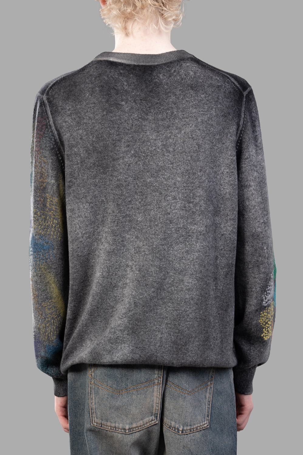 Back close-up of grey cashmere sweater with subtle painted detail at sleeves and ribbed hem