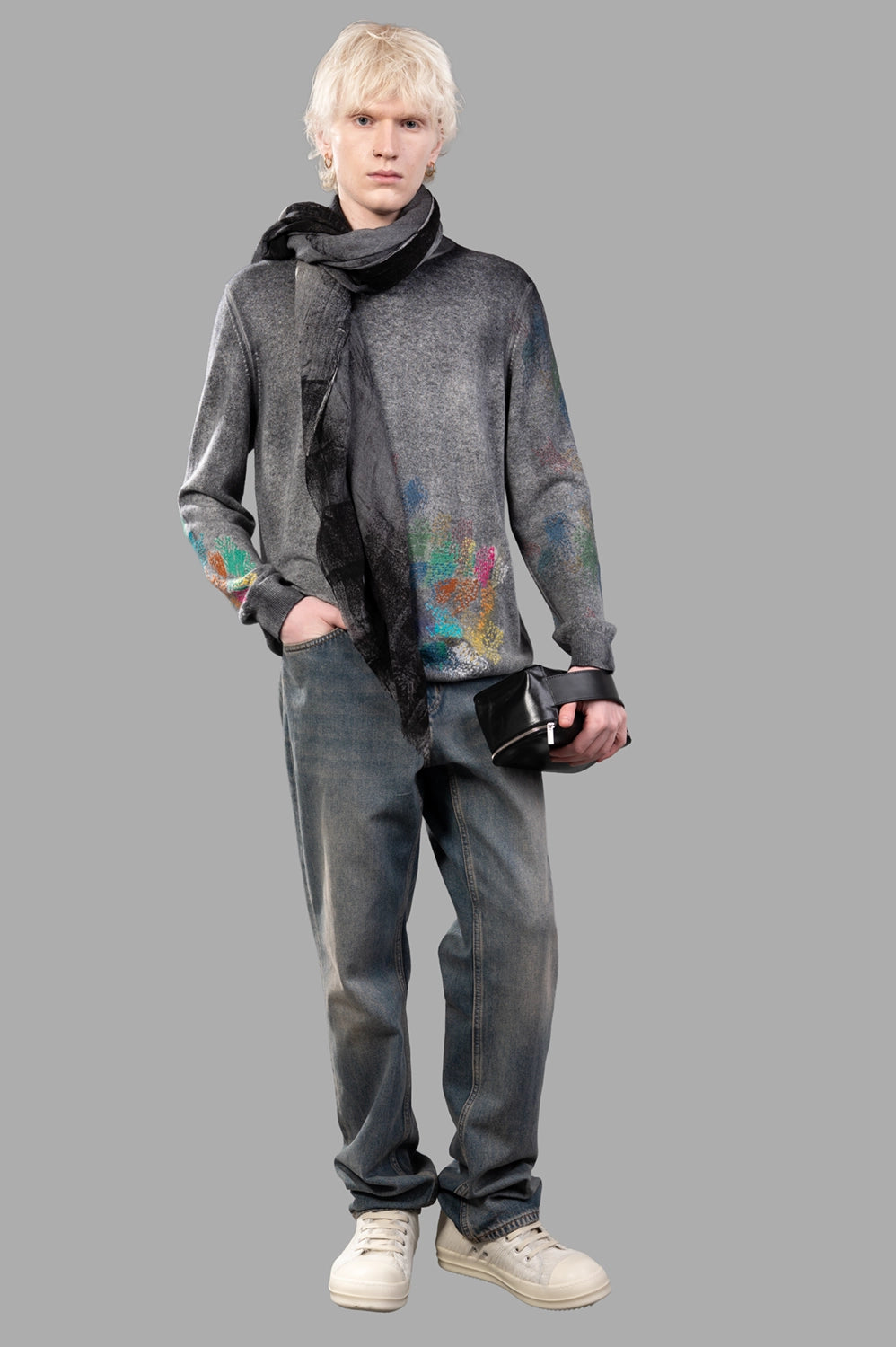 Full-length view of grey cashmere sweater with multicolour hand-painted details, worn with jeans