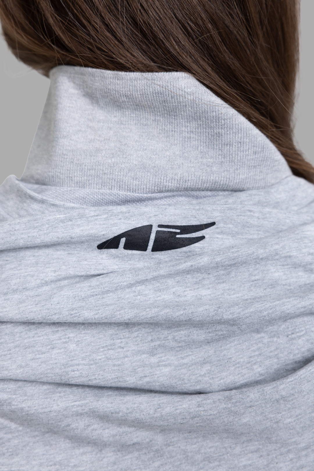 Natasha Zinko women's grey multi layer long sleeve T-shirt, close-up of ribbed mock neck and black logo on back draped layer