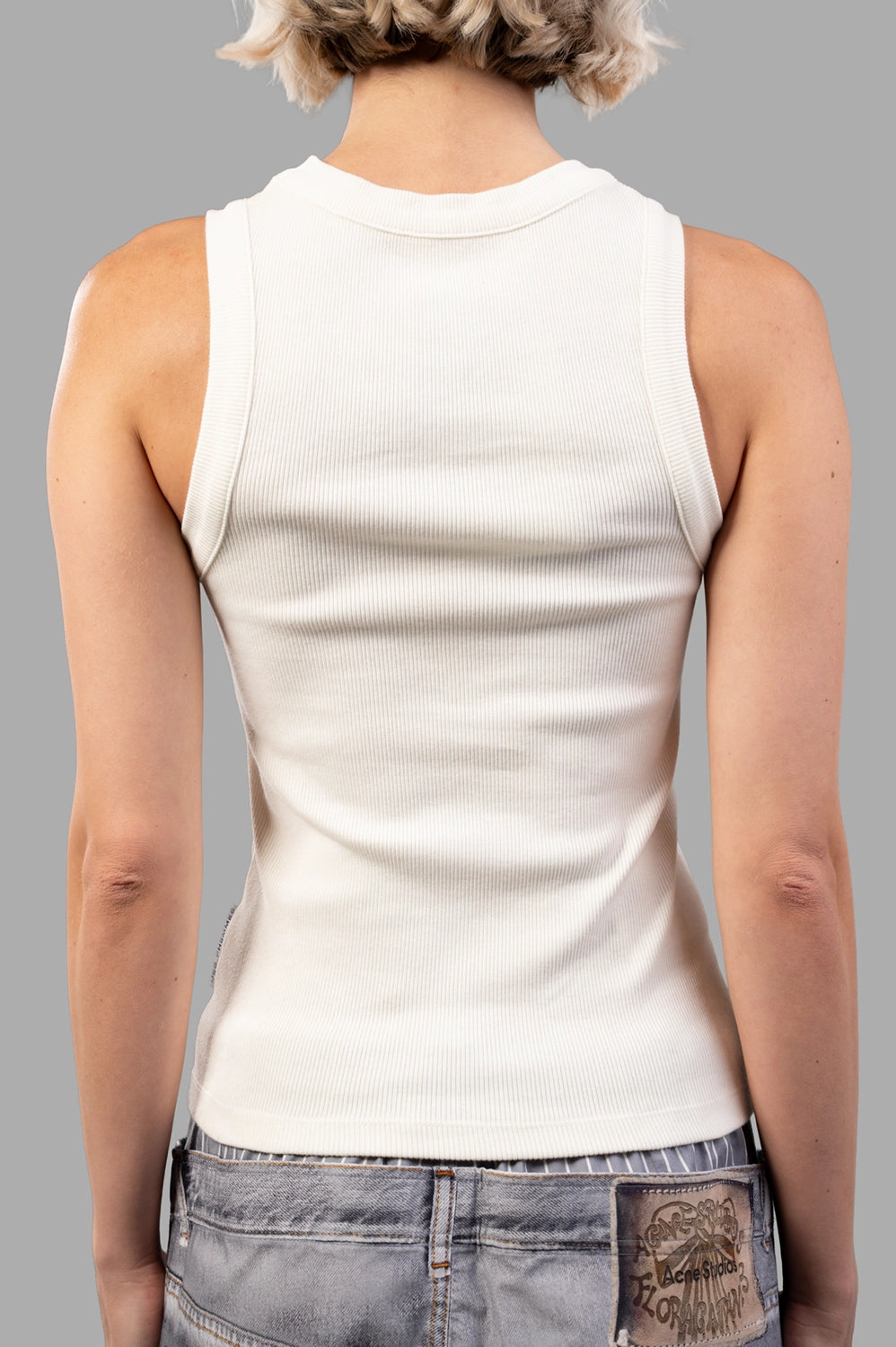 Back view of creme ribbed tank top showing clean racer-style armholes and straight hem
