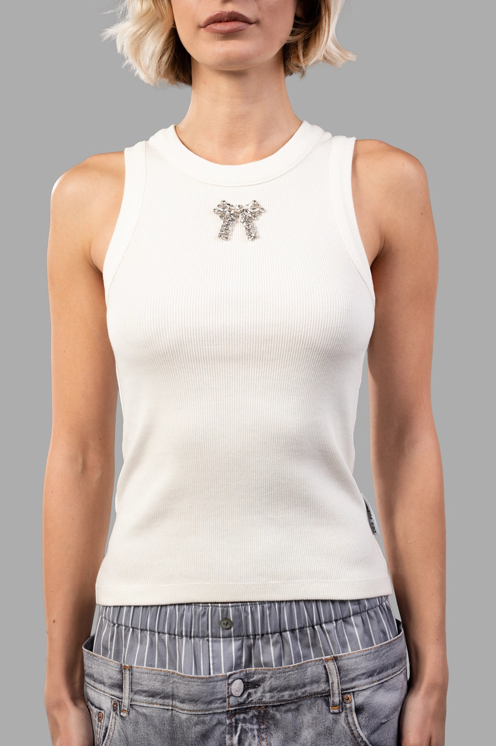 Front close-up of creme ribbed tank; round neck with wide binding and crystal bow at center
