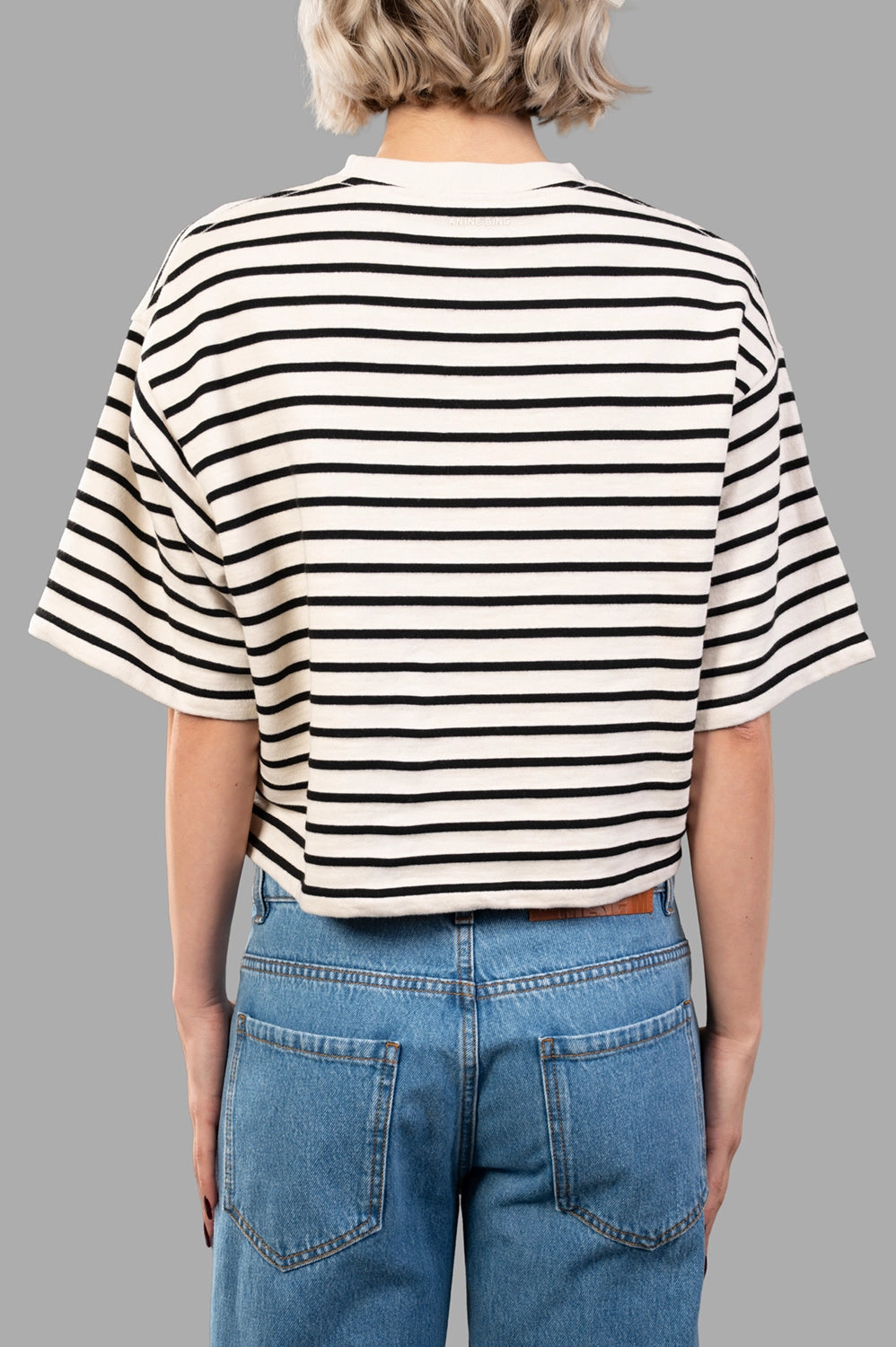 Back detail view of cropped striped tee featuring dropped shoulder seam and clean knit finish