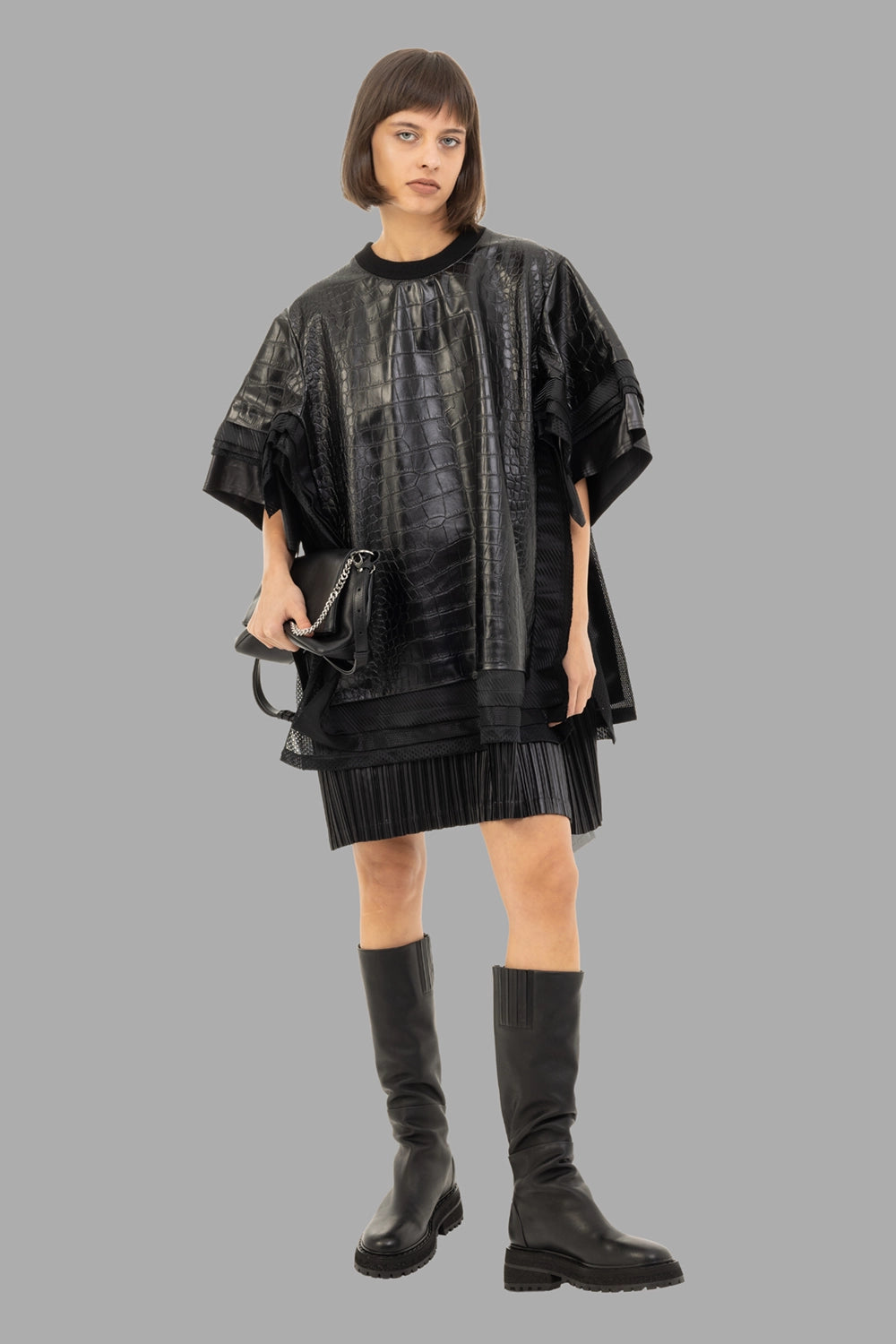 Junya Watanabe women’s faux-leather top in black, full length on model, oversized drape and layered hem
