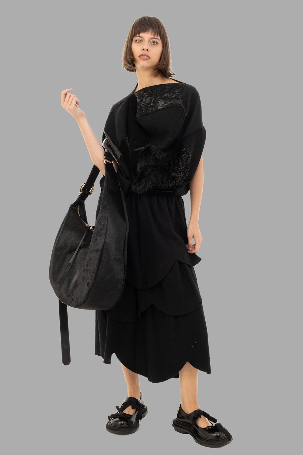 Junya Watanabe women patchwork top in black, on-model full length, asymmetric drape and mixed textures.