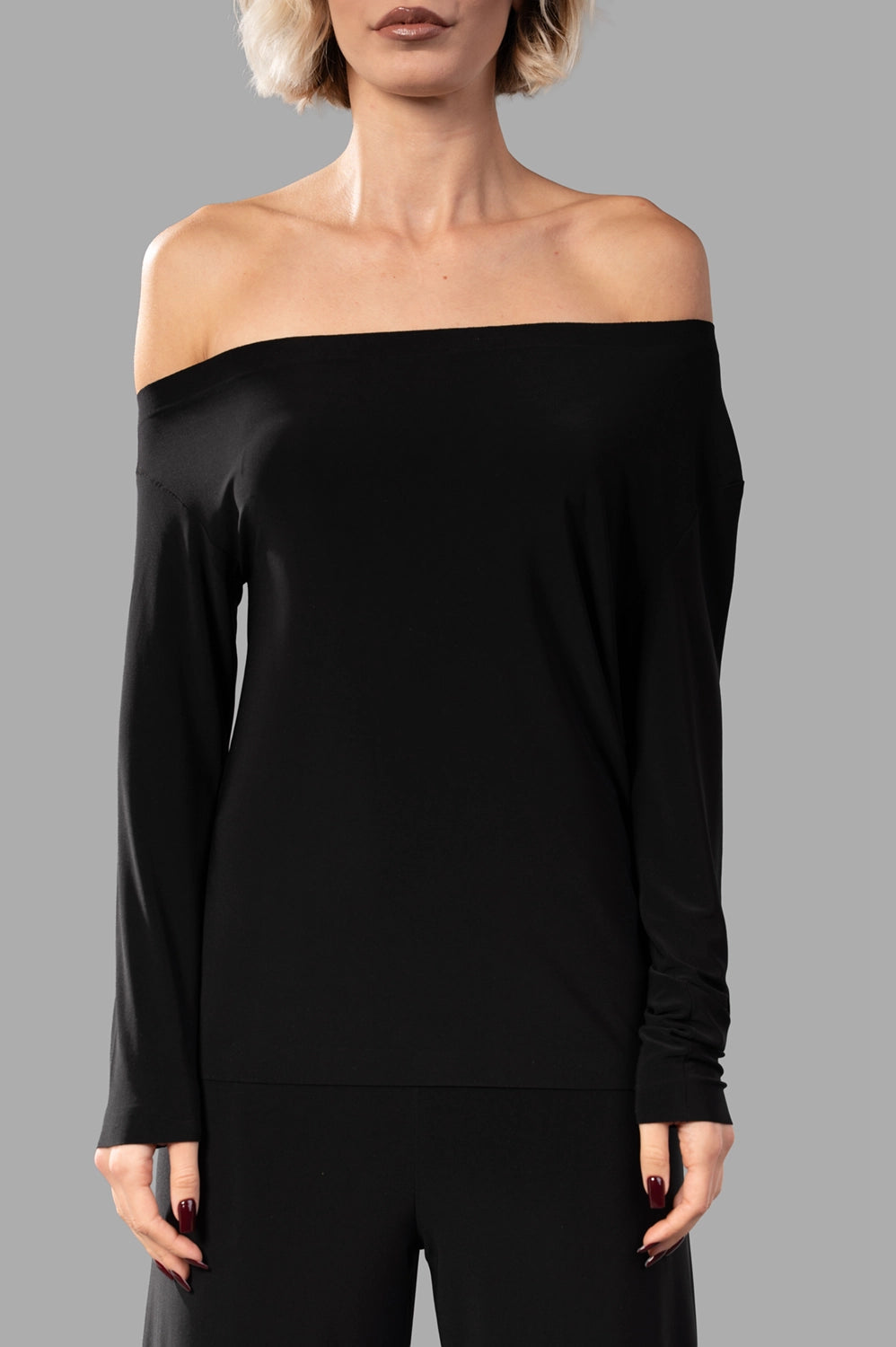 Norma Kamali top in black, front view, slim fit and raw‑cut neckline visible