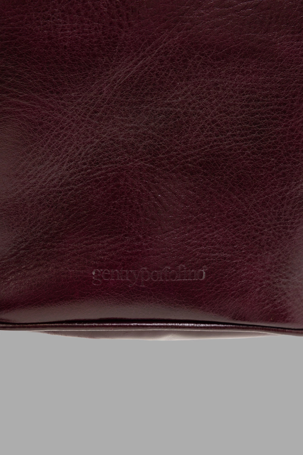 GentryPortofino women's top-handle bag in Borgogna, logo close-up, debossed logo and pebbled texture.